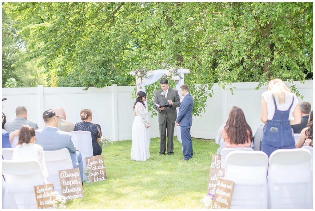 Bride and Groom stand under ceremony arch during their intimate NJ wedding ceremony captured by NJ wedding photographer Diana and Korey Photo and Film