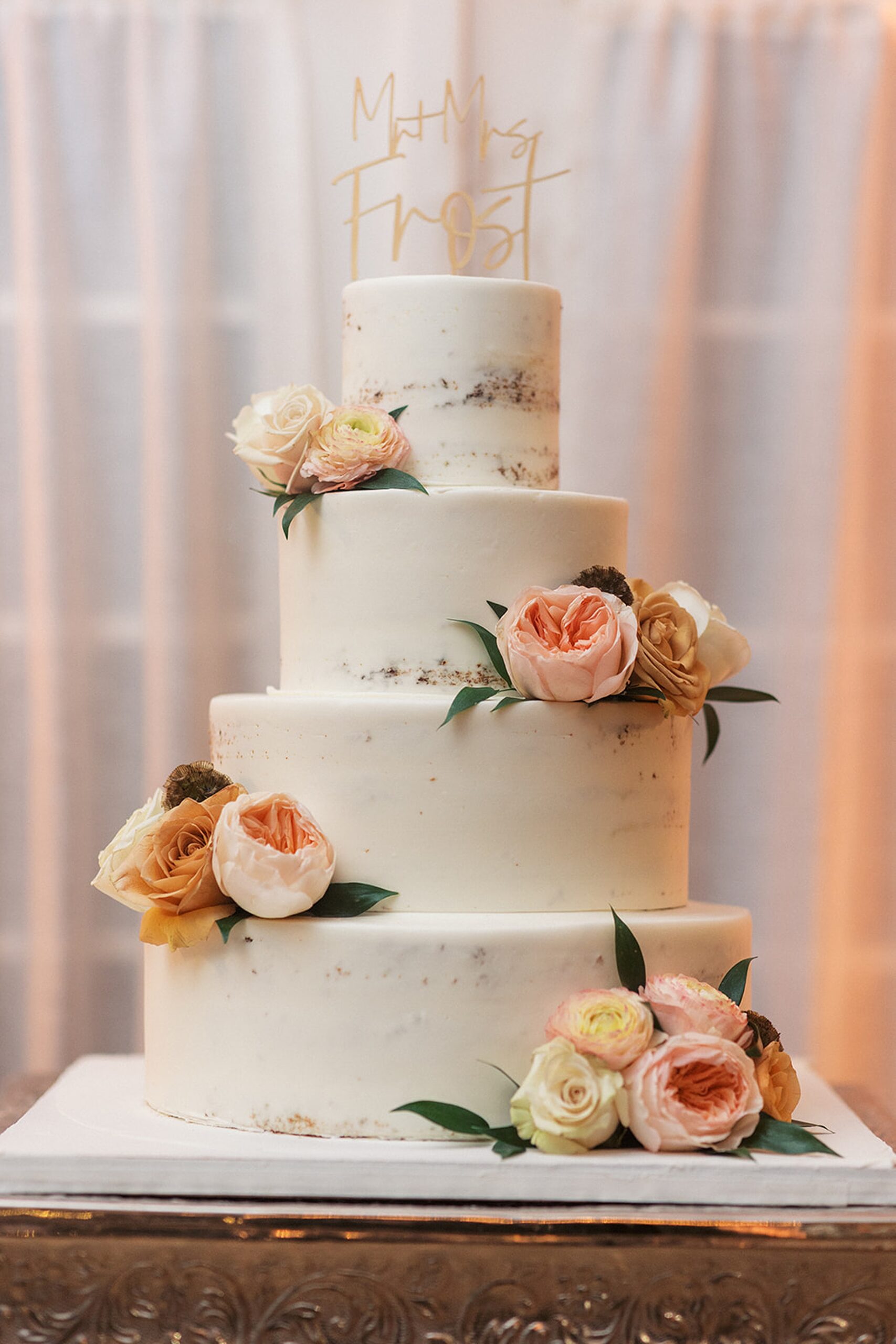 Details of a four tier wedding cake decorated with flowers