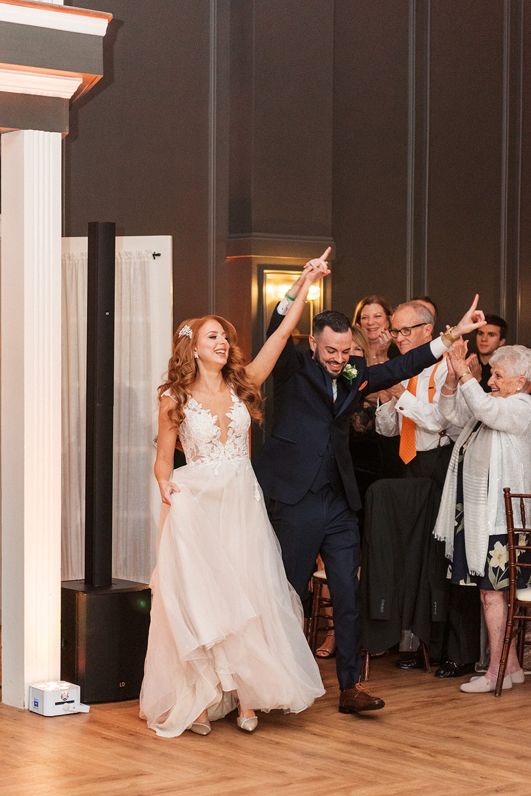 Newlyweds celebrate with heir guests as they enter the wedding reception