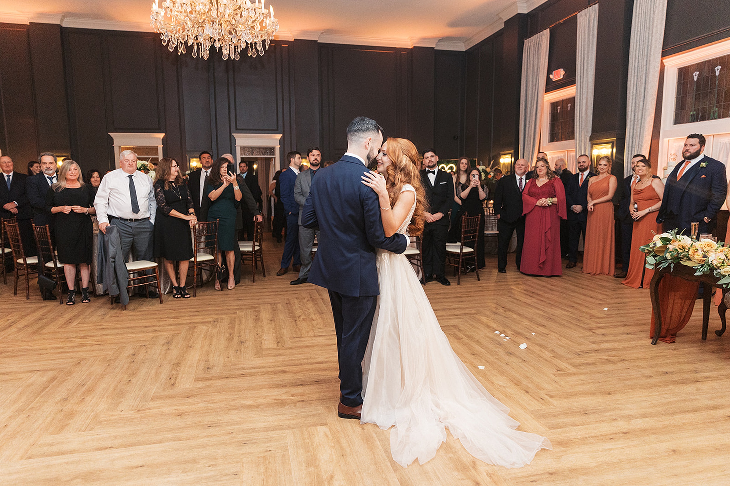 Newlyweds dance close while their guests look on