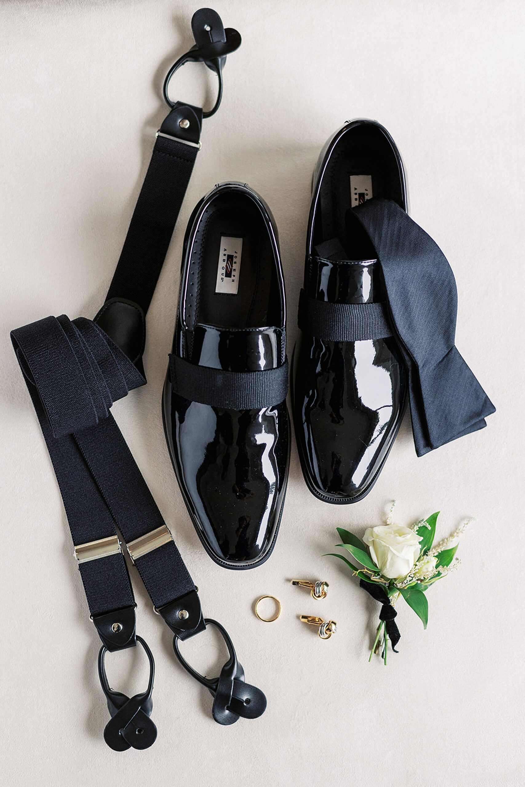 Details of a groom's shoes, ring, cufflinks, suspenders and boutanier
