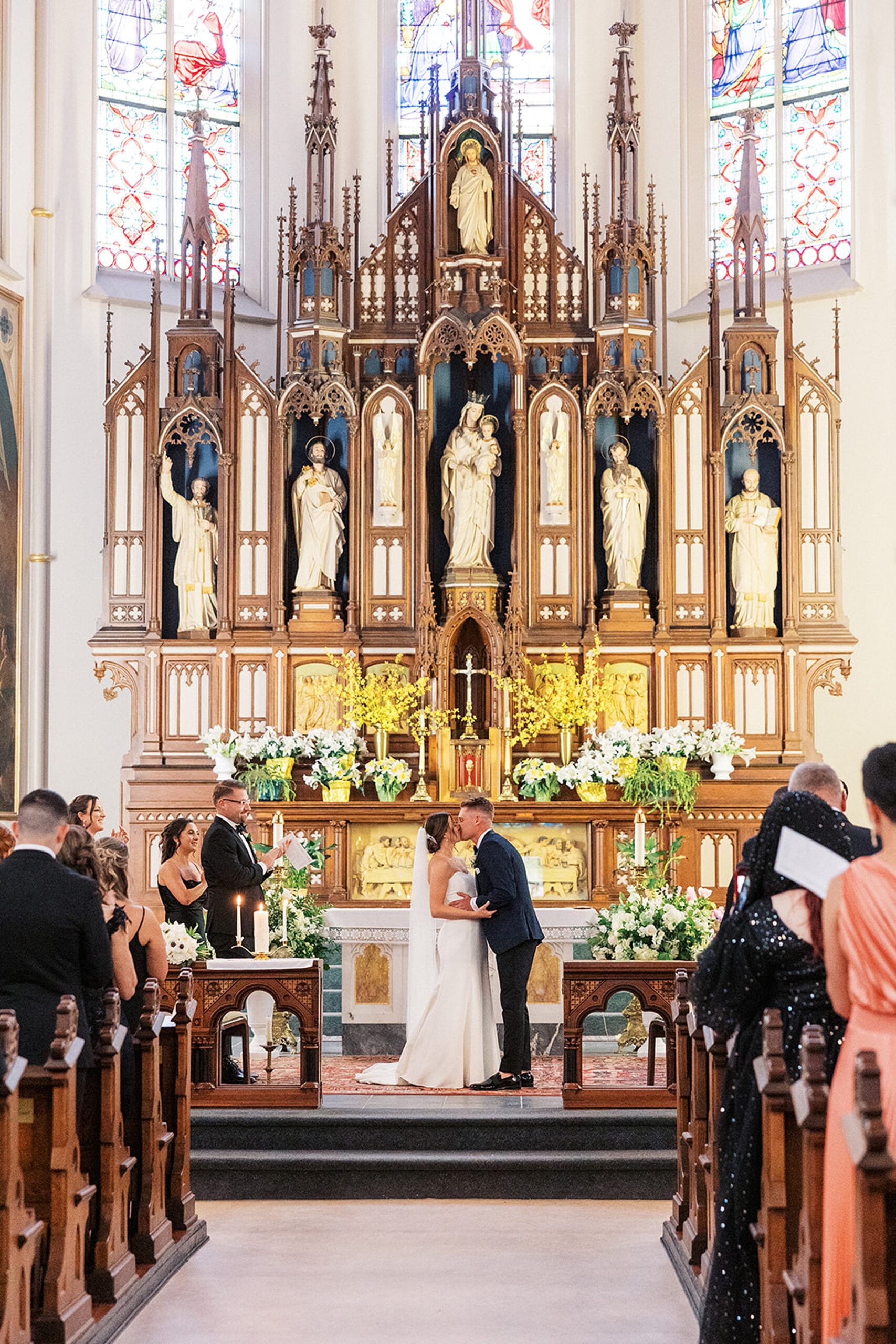 Newlyweds kiss at the altar of an ornate church