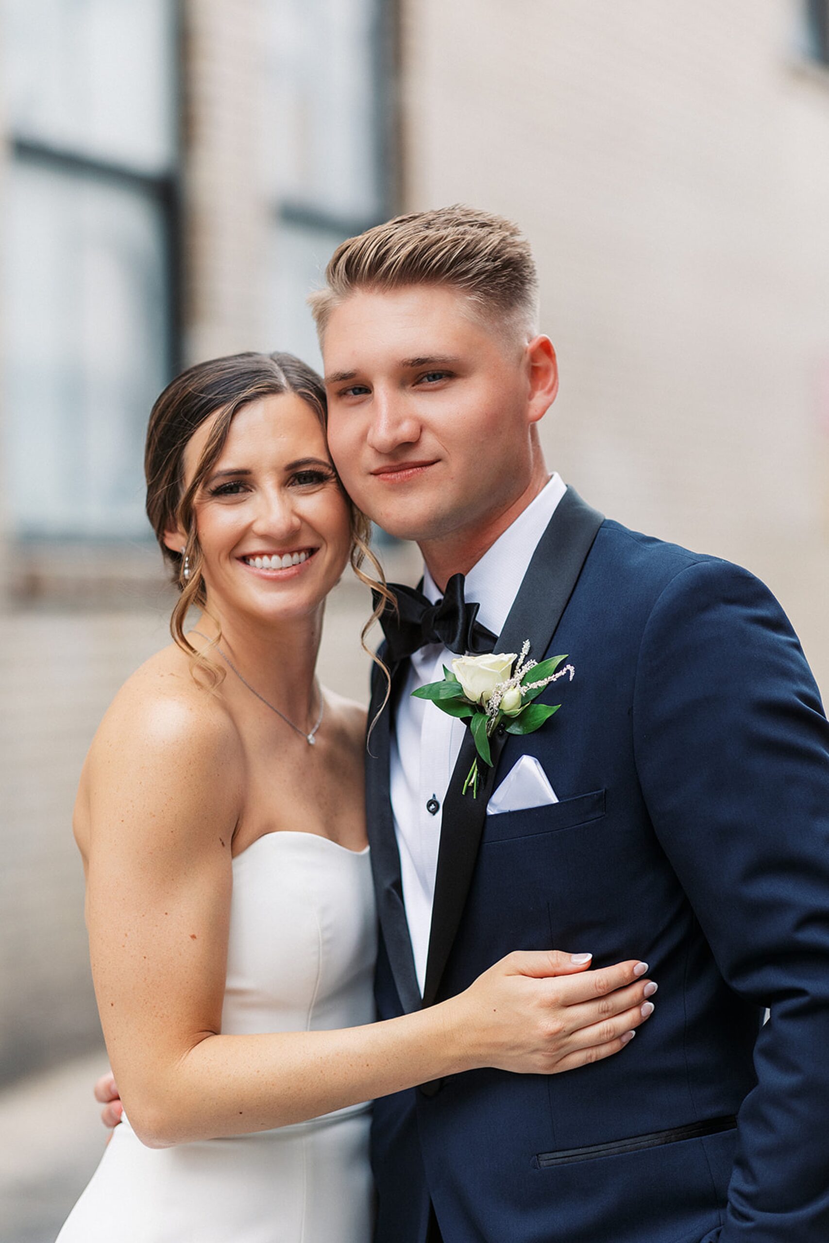 Newlyweds embrace in an alley