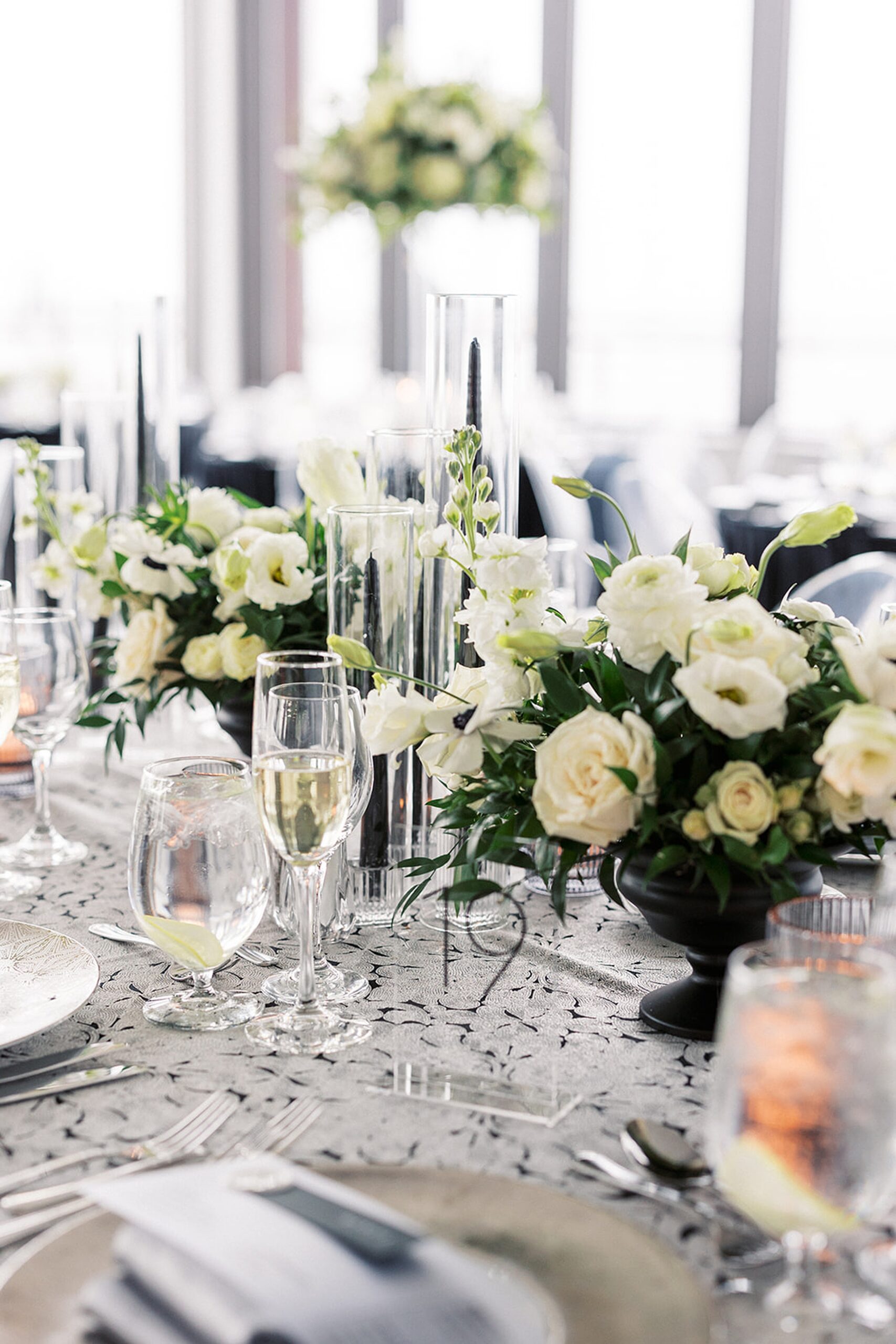 Details of a wedding reception table set with champagne and white rose centerpieces at a Hudson House wedding