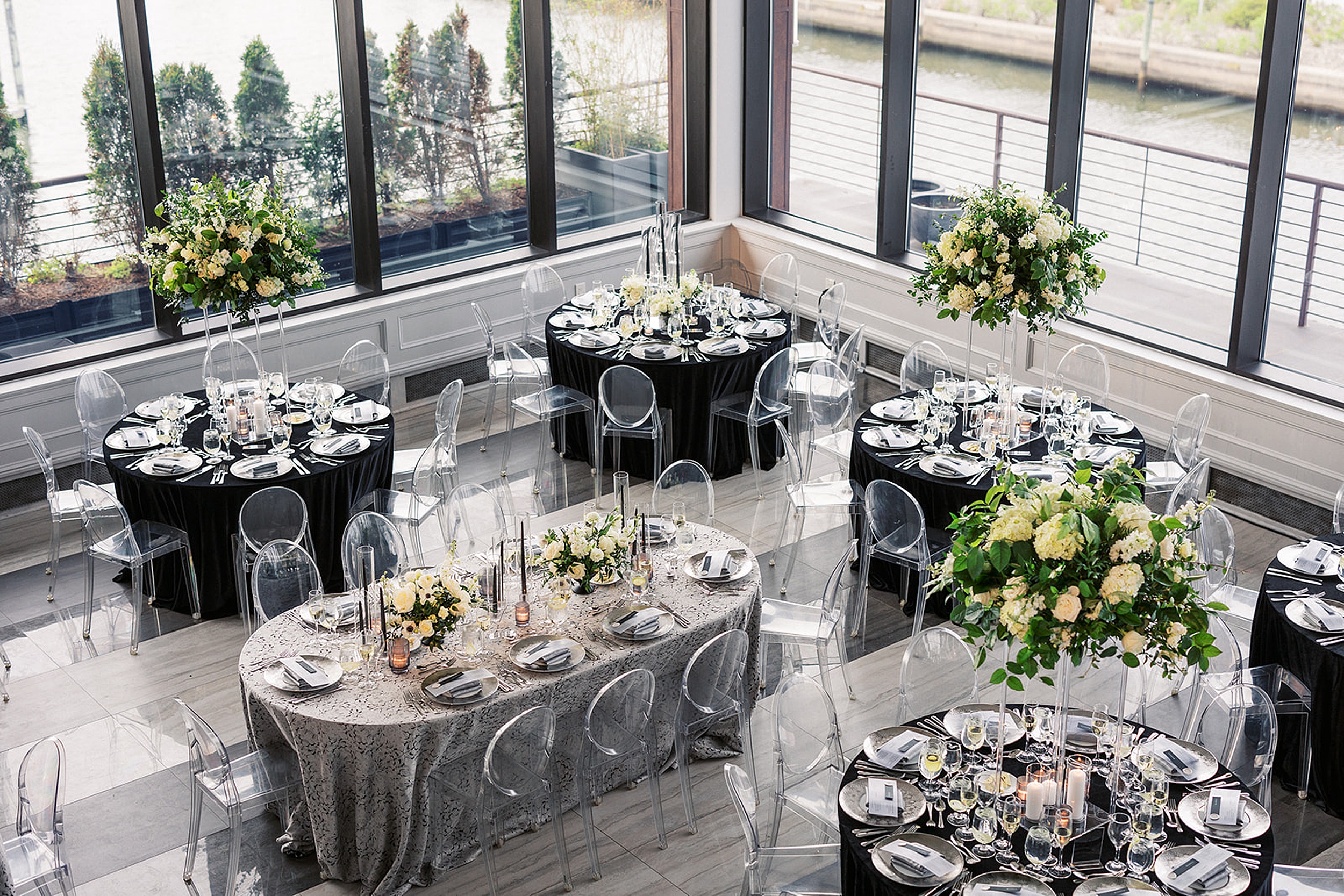 Details of a wedding reception setup with black linen and clear plastic chairs at a Hudson House wedding