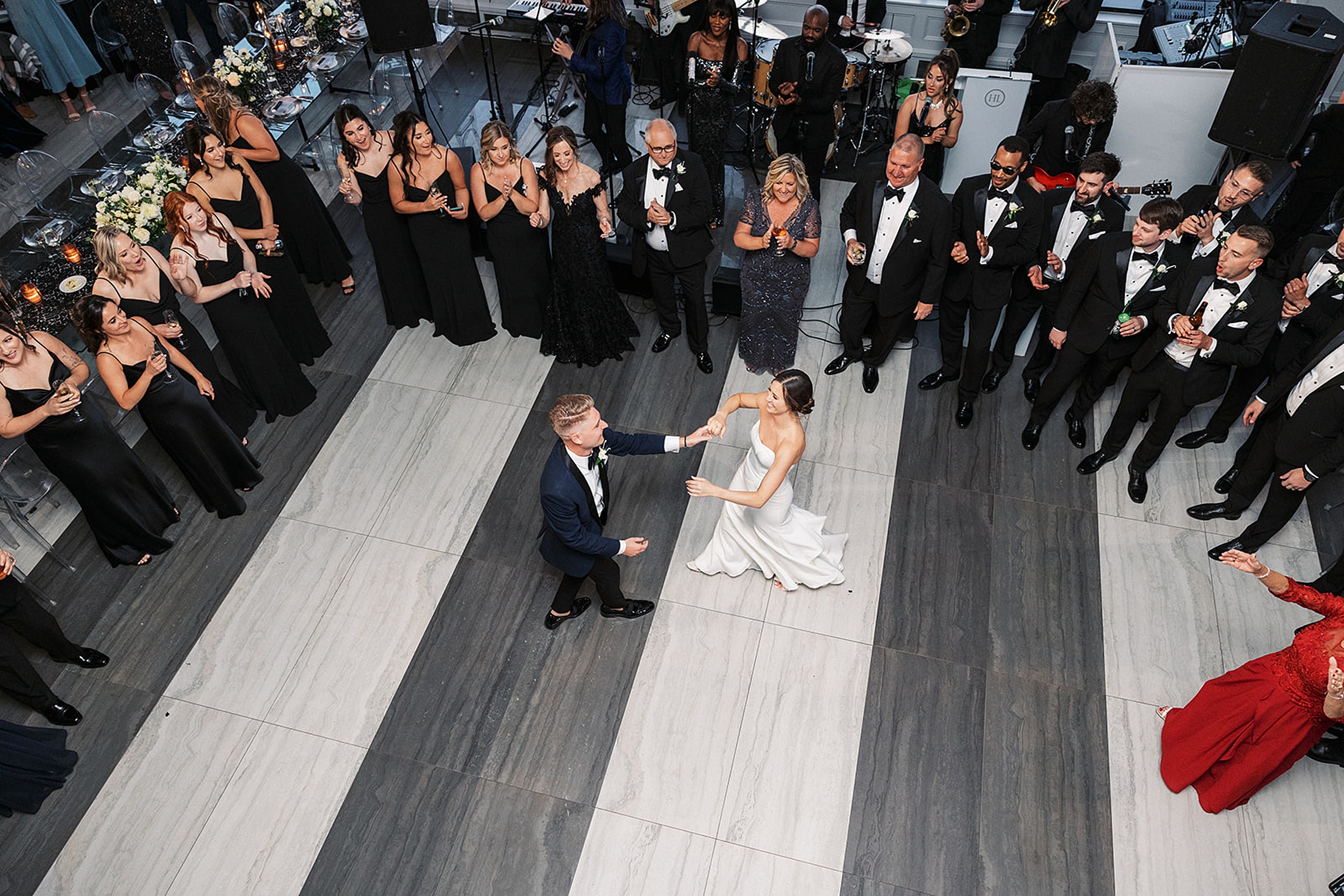 Newlyweds dance on the dance floor with a live band surrounded by their guests at a Hudson House wedding