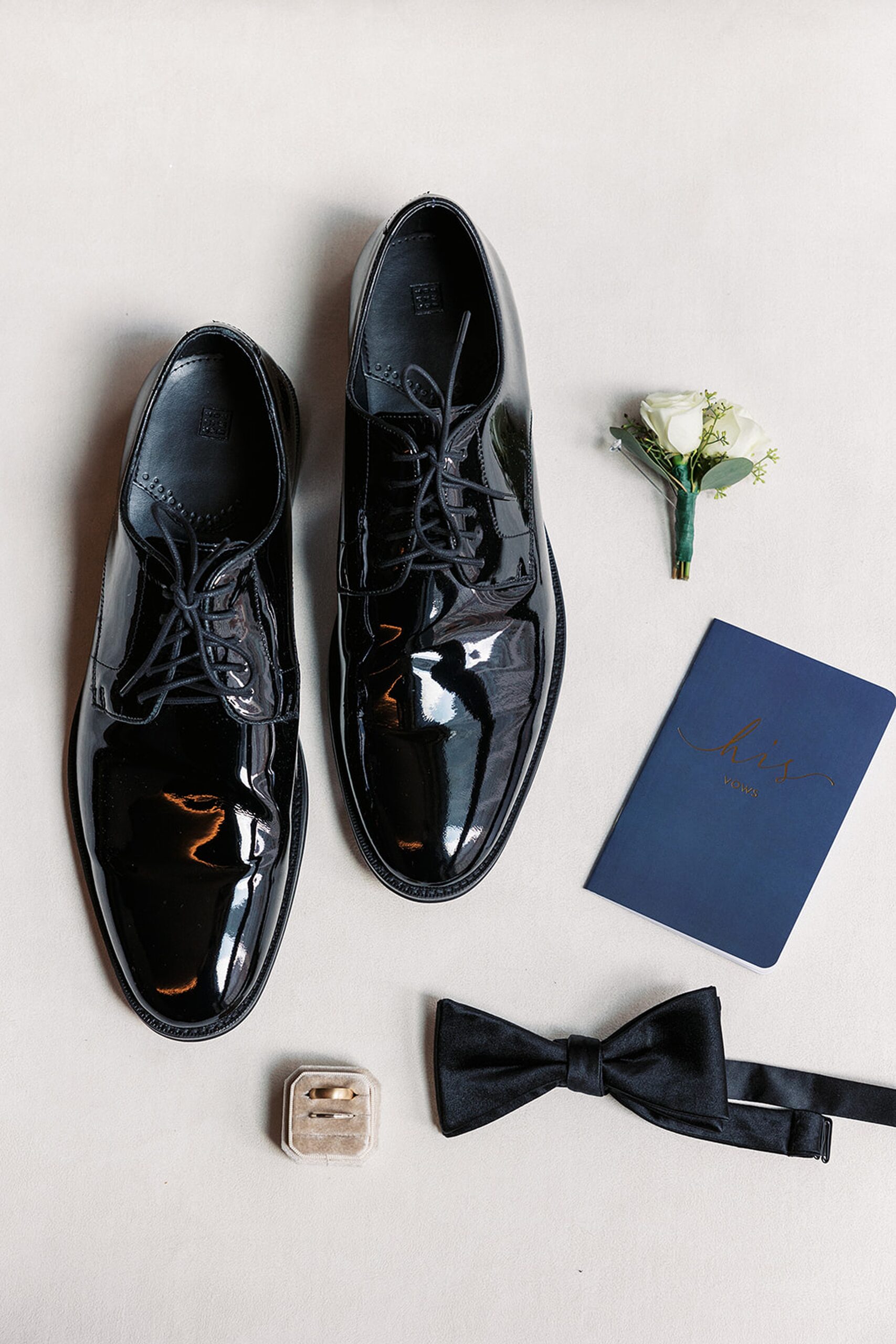 Details of a groom's shoes, rings, boutonniere and bowtie