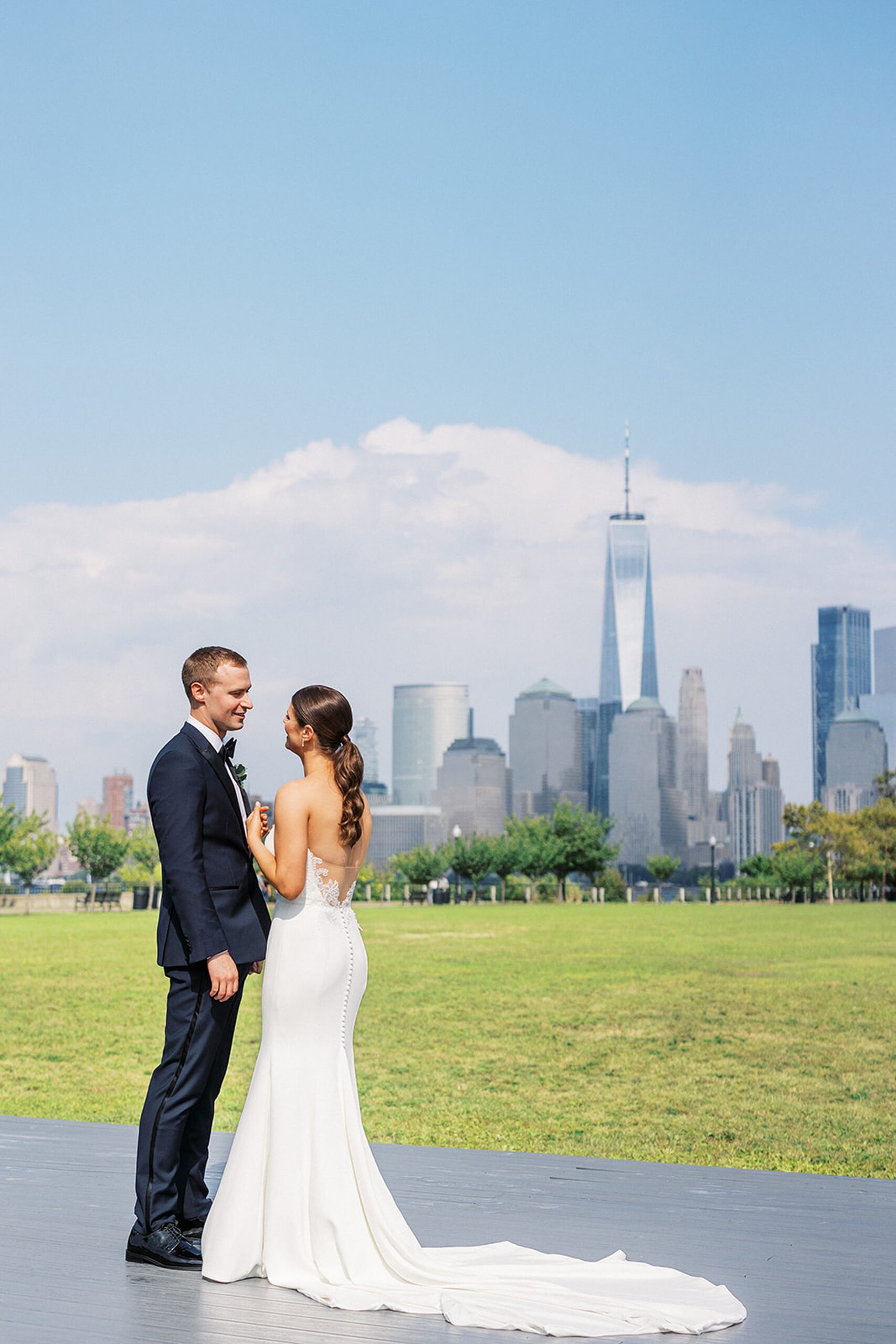 Newlyweds laugh and chat while looking out at the New York City Skyline