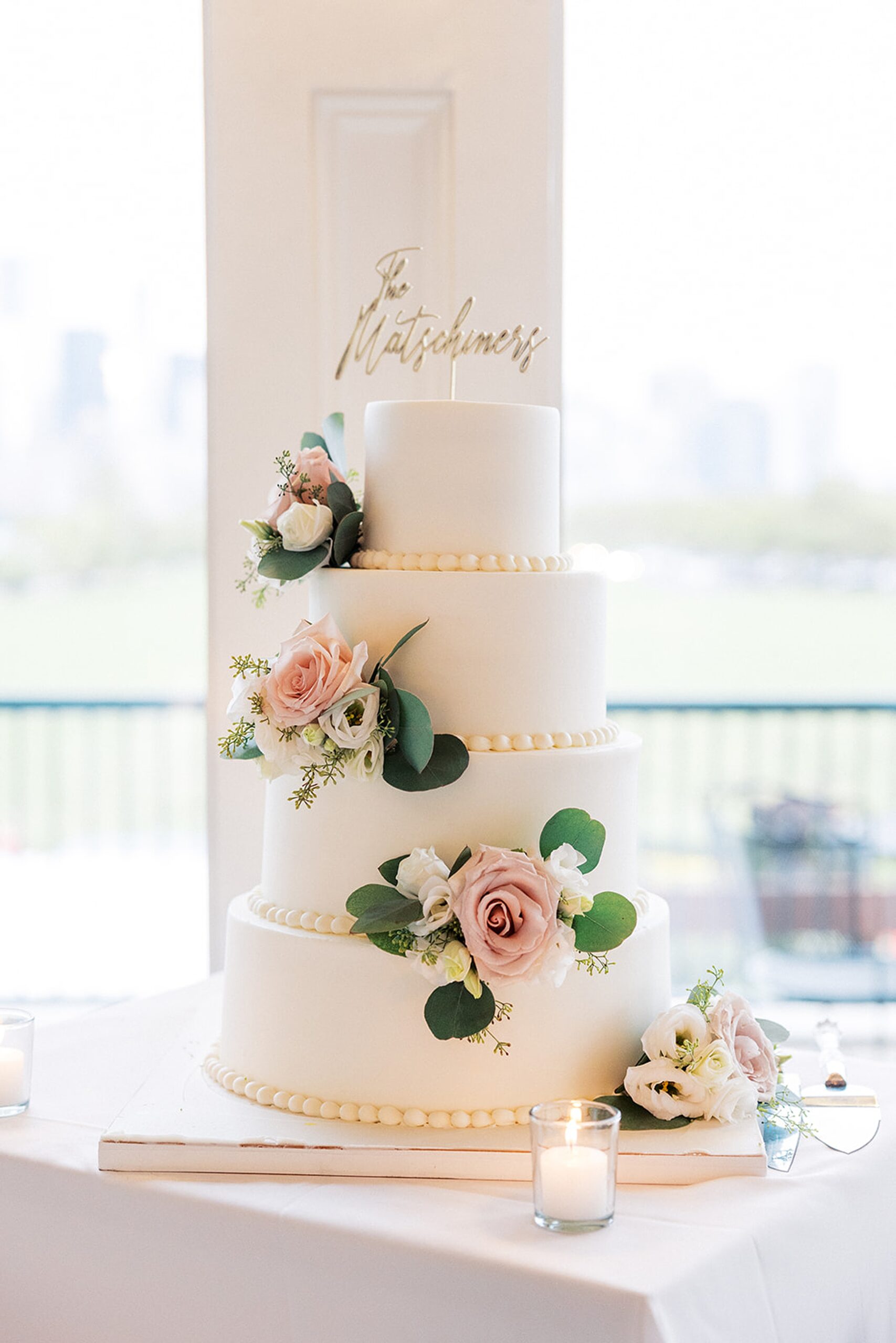 Details of a four tier cake with pink flowers