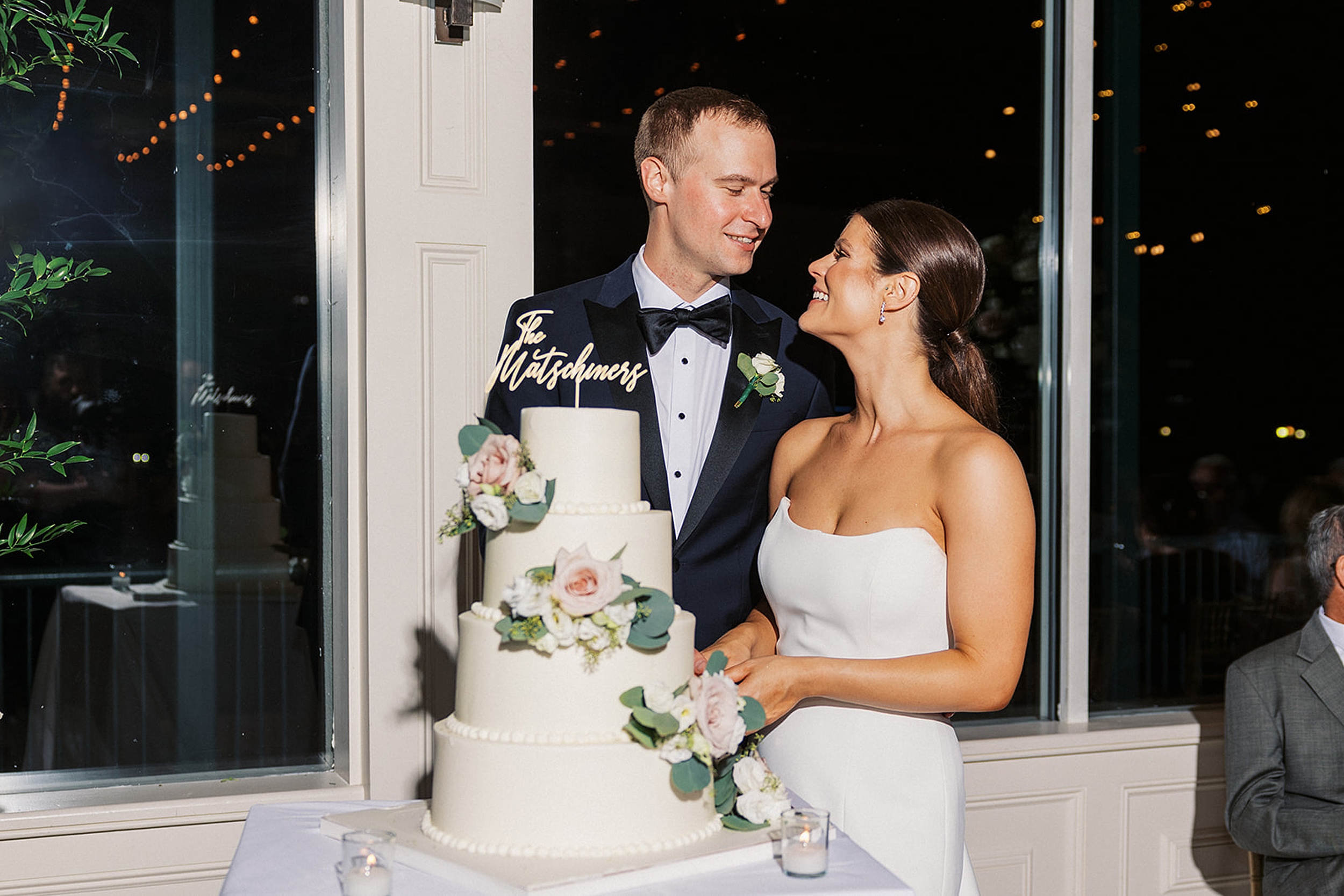 Newlyweds look at each other as they both cut the cake at their Liberty House Wedding