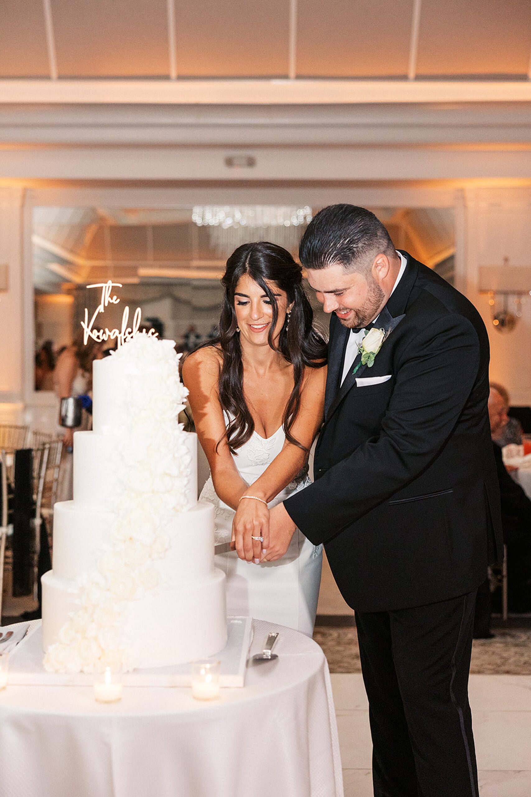 Newlyweds cut their four tier white wedding cake together at a edgewood country club wedding