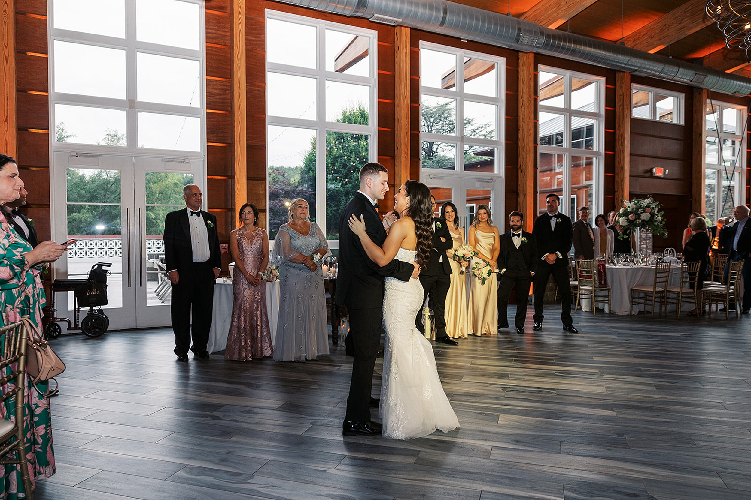 Newlyweds dance on a dance floor as their guests look on