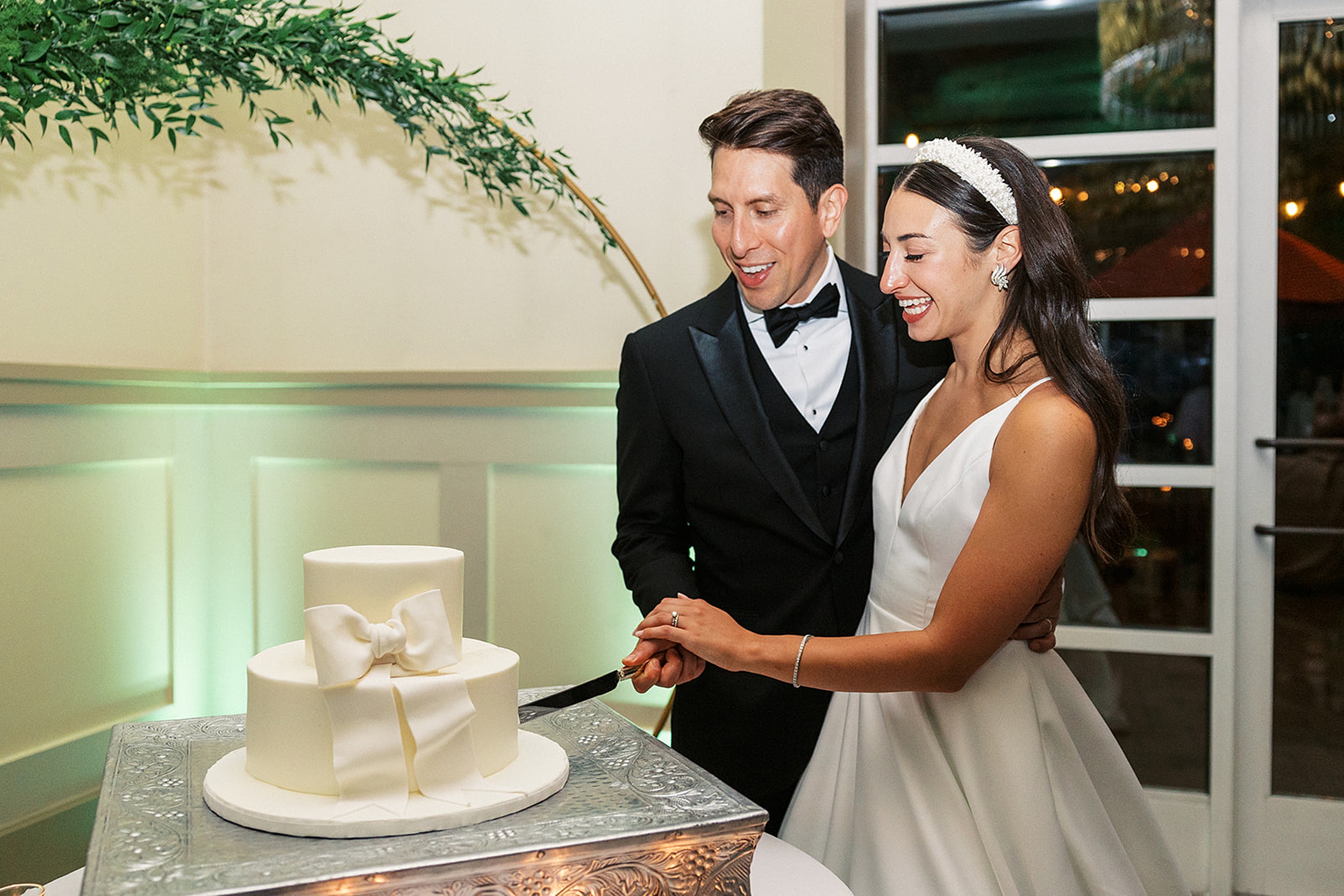 Newlyweds hold the knife and cut the cake together at their Stonehouse At Stirling Ridge Wedding