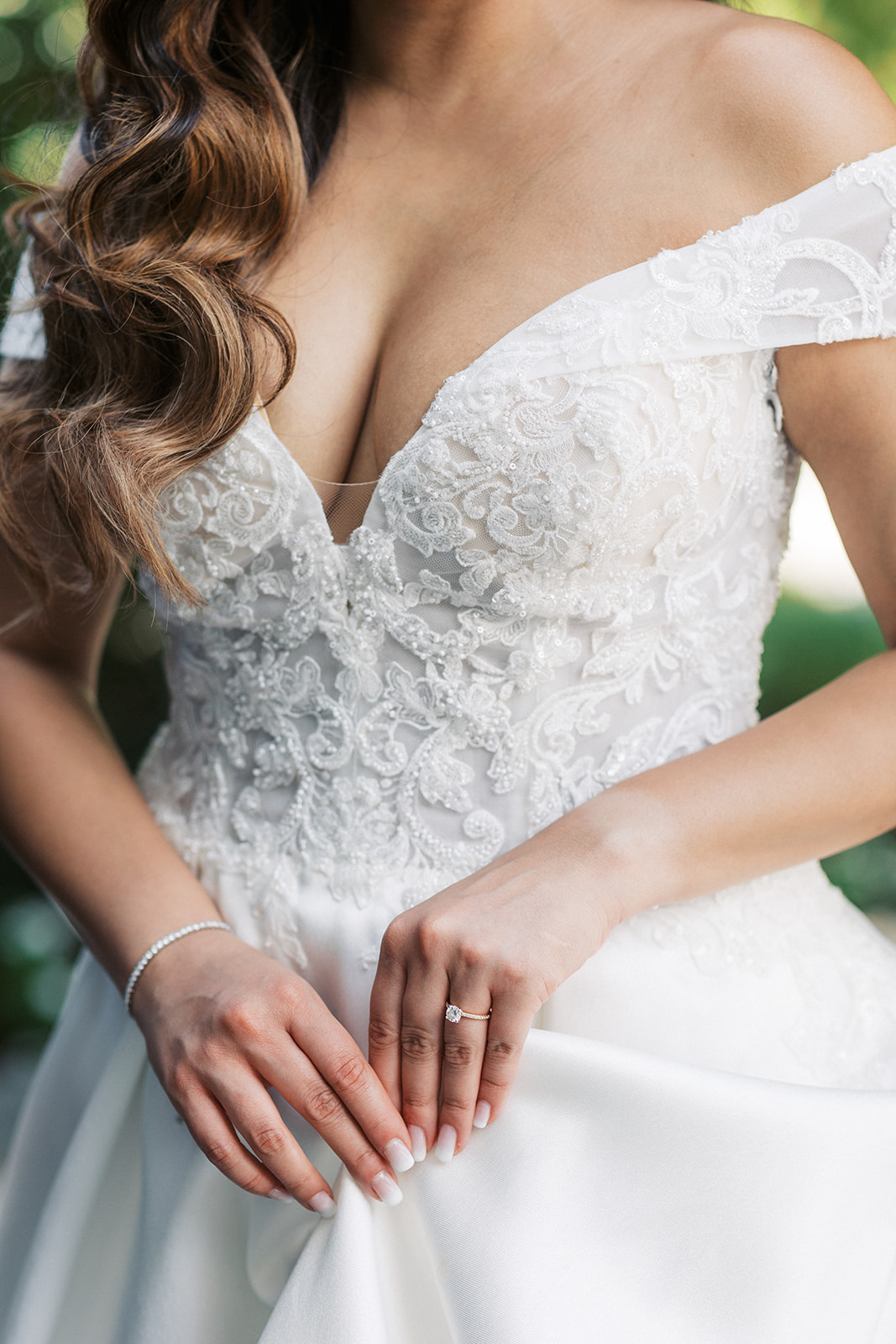 Details of a bride's lace dress as she holds her train at an Addison Park Wedding