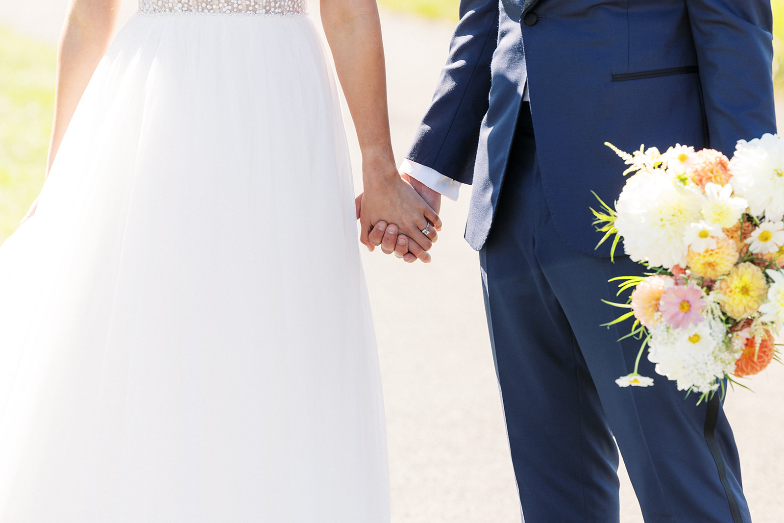 Details of newlyweds holding hands while walking down a sidewalk at a Birchwood Manor Wedding