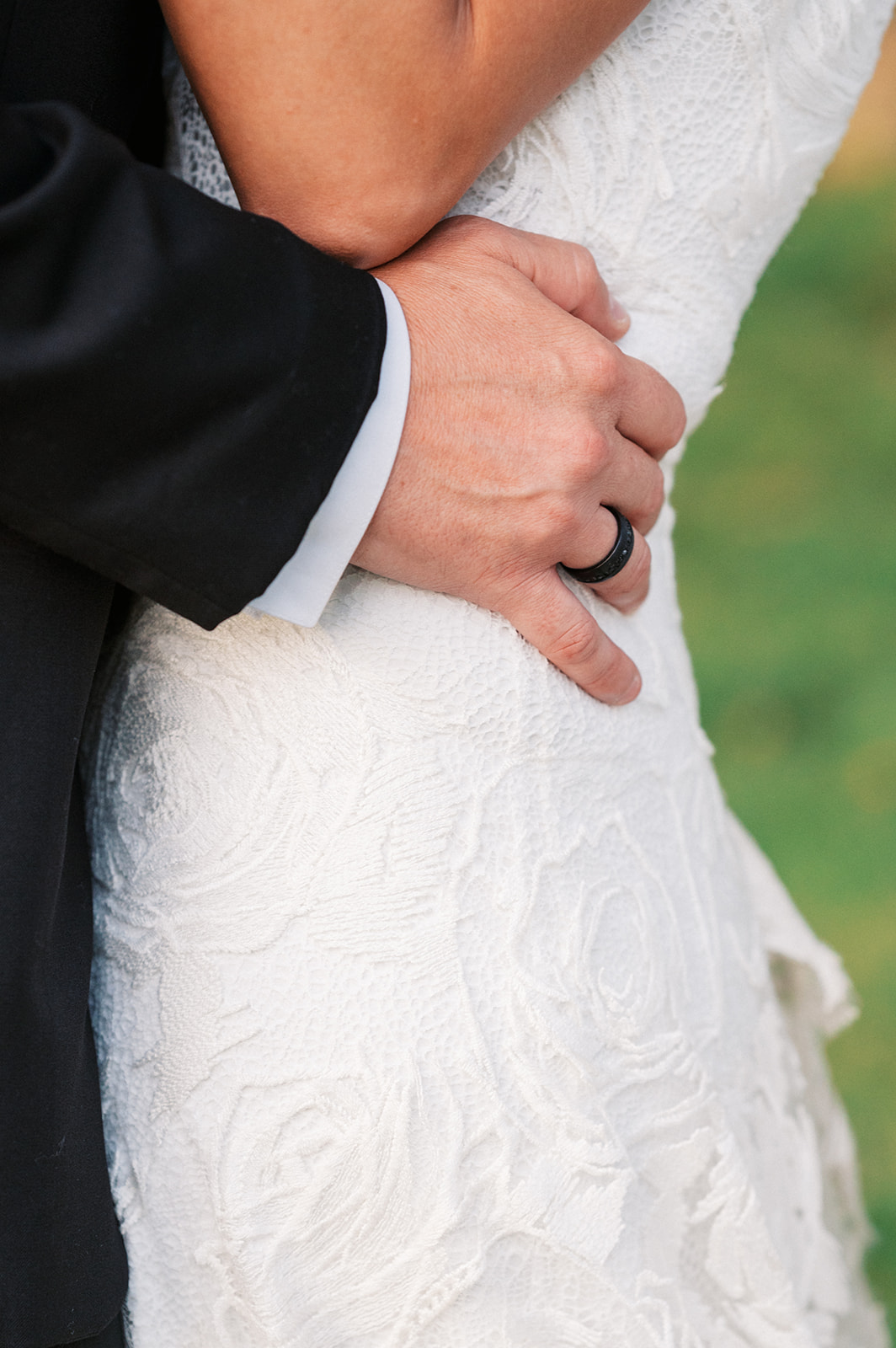 Details of a groom's hand on his bride's white lace dress at a Ravello East Hanover Wedding