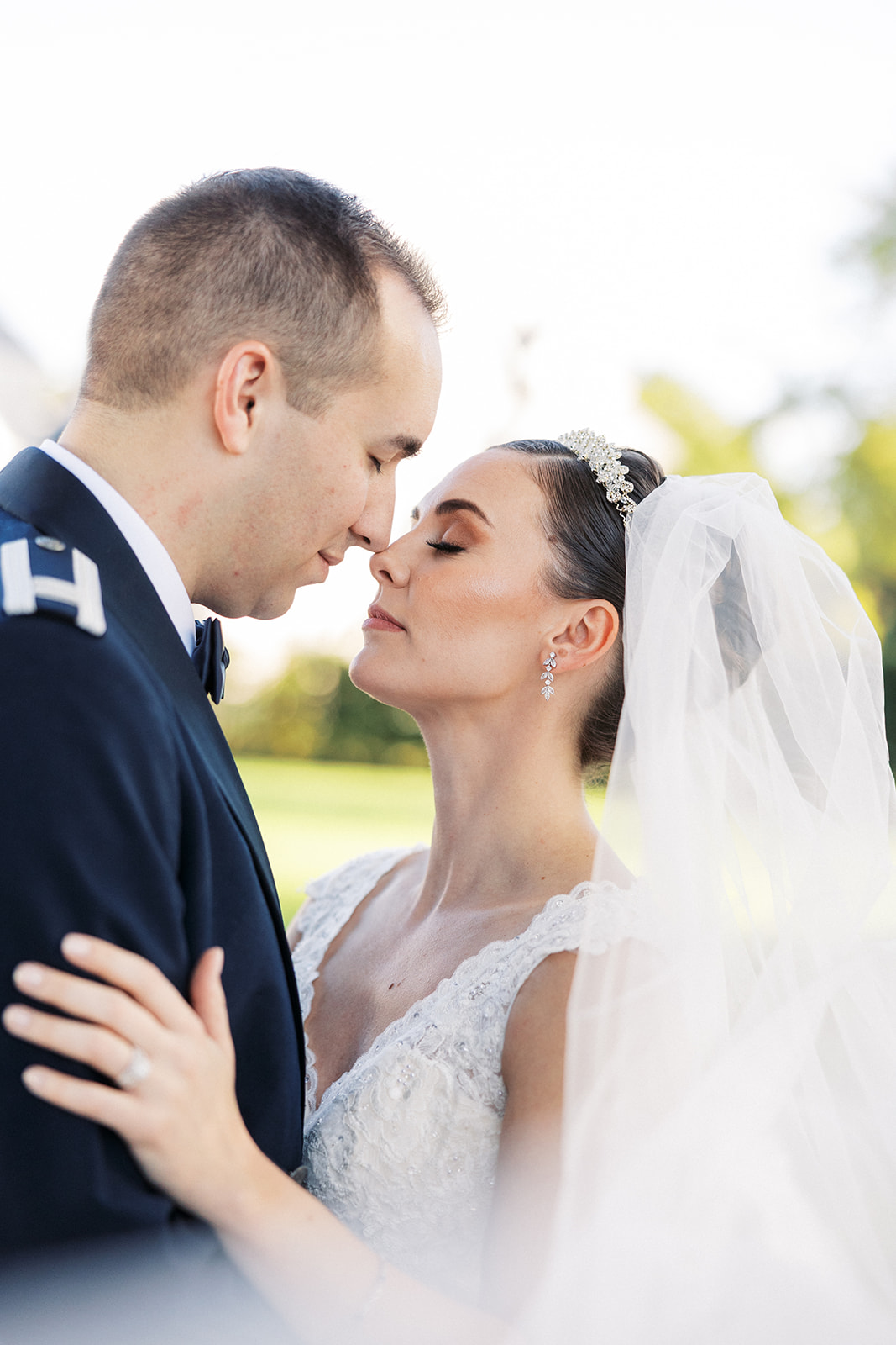 Newlyweds dance and lean in for a kiss in a white lace dress and military jacket at a The Mansion at Mountain Lakes wedding
