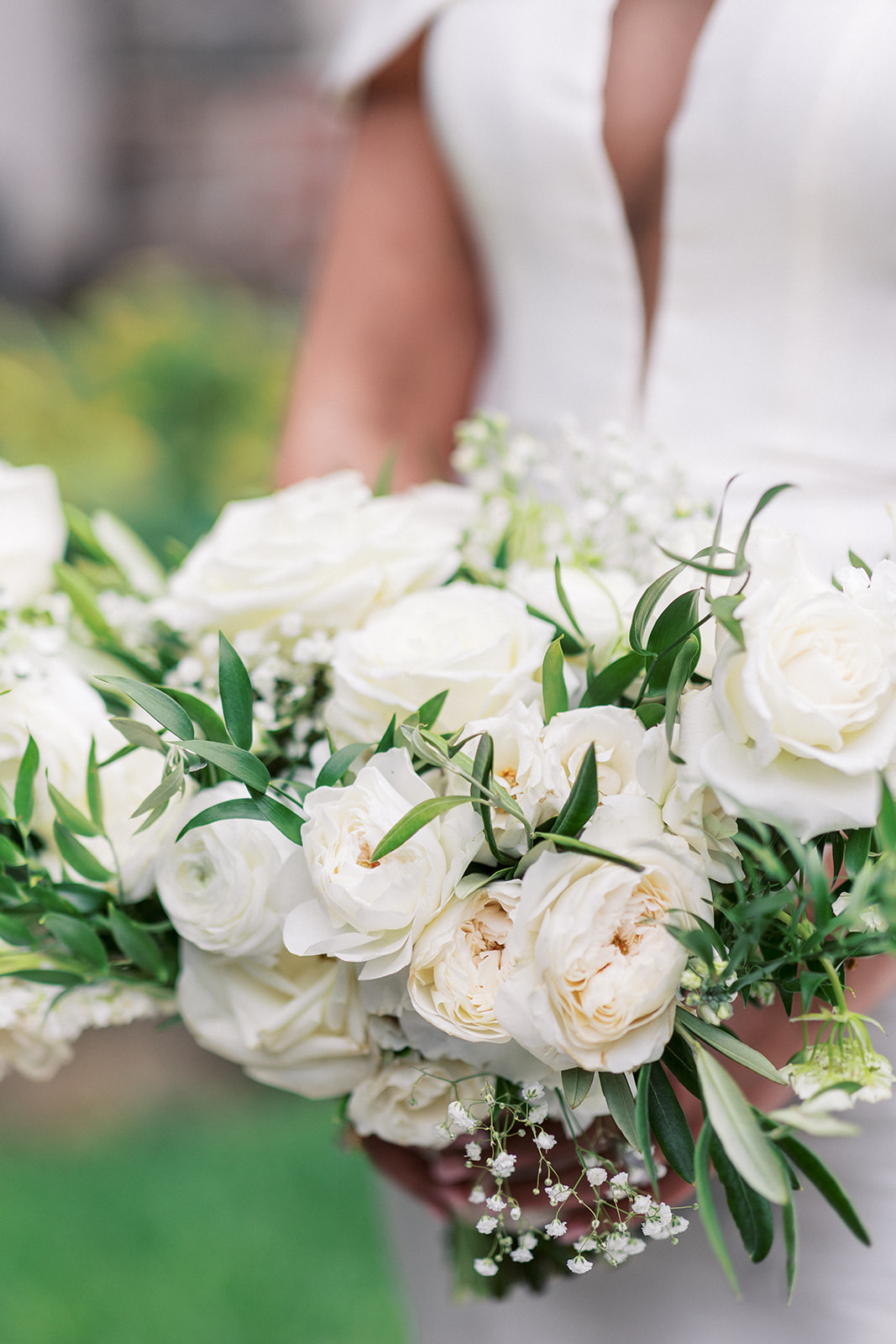 Details of a bride holding her white rose bouquet at The Meadow Wood Wedding venue