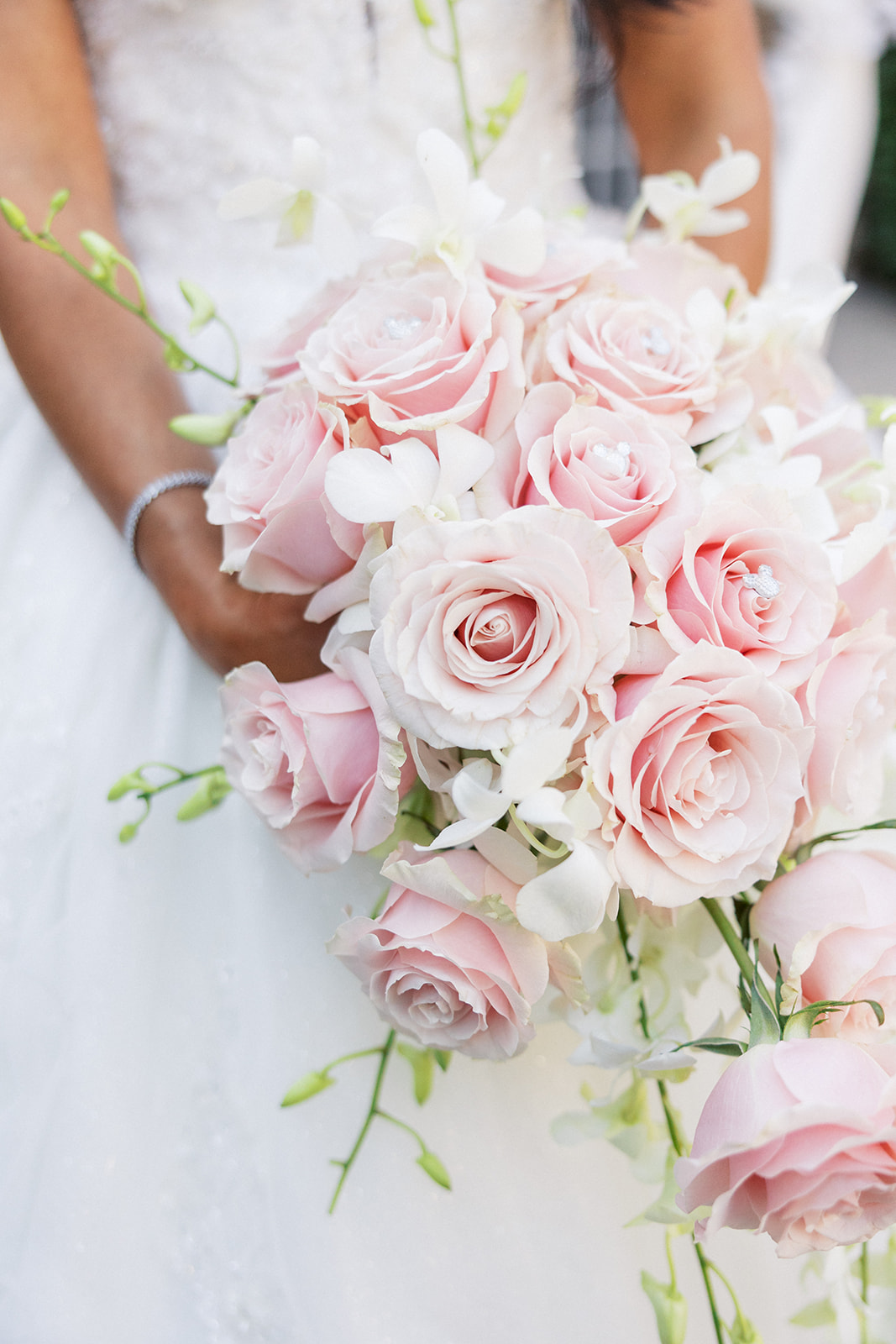 Details of a bride's pink flower bouquet as she holds it