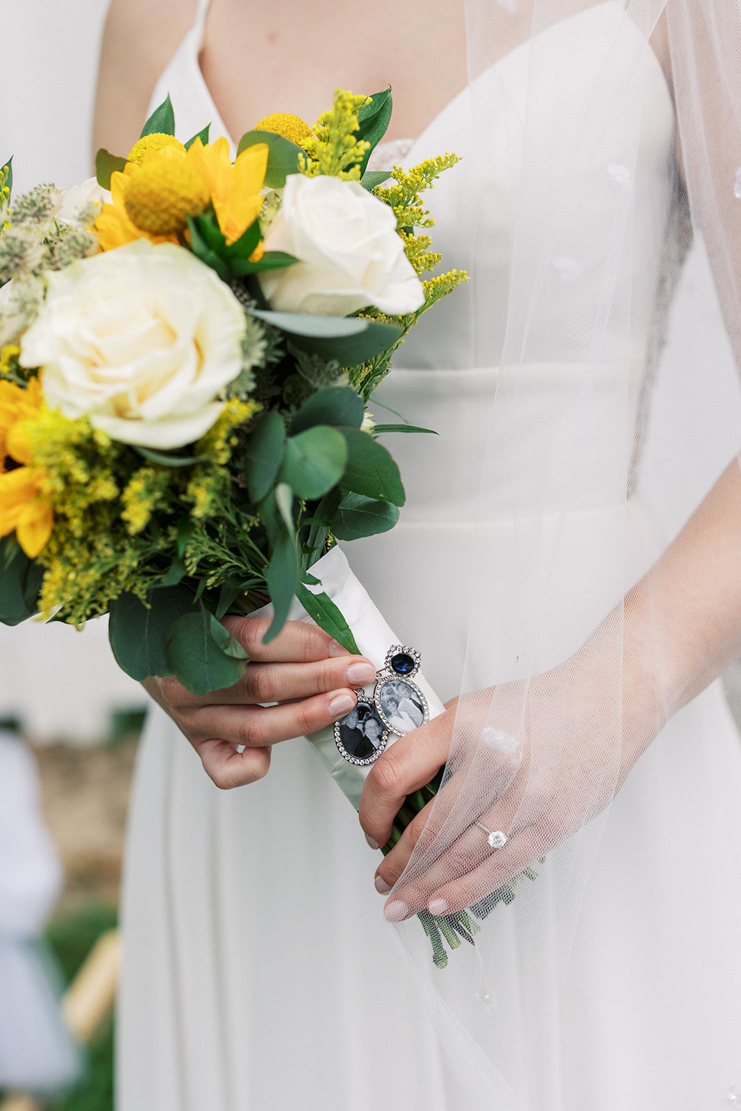 Details of a bride holding her white and yellow bouquet