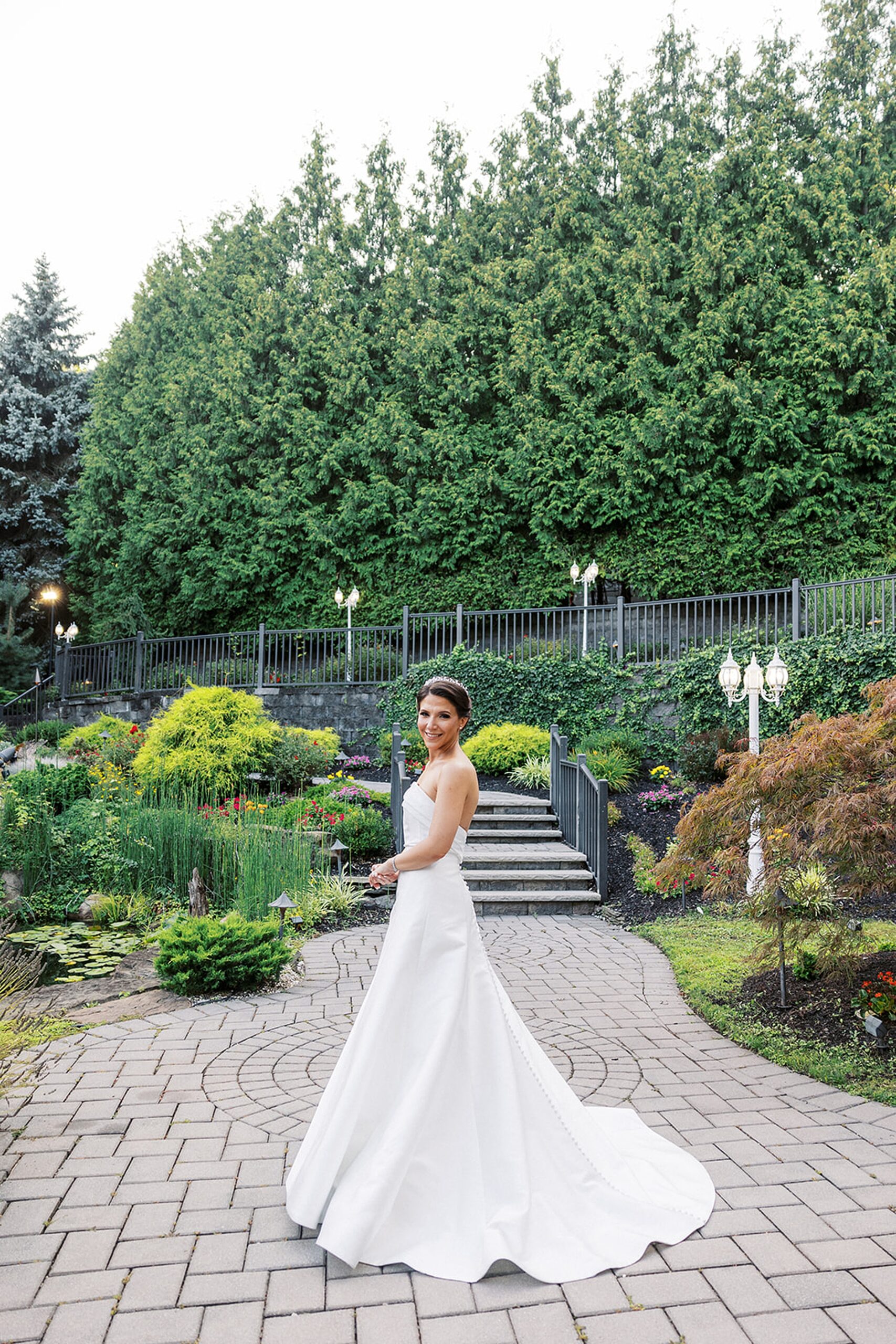 A bride twirls in her silk dress in a garden path at a valley regency wedding