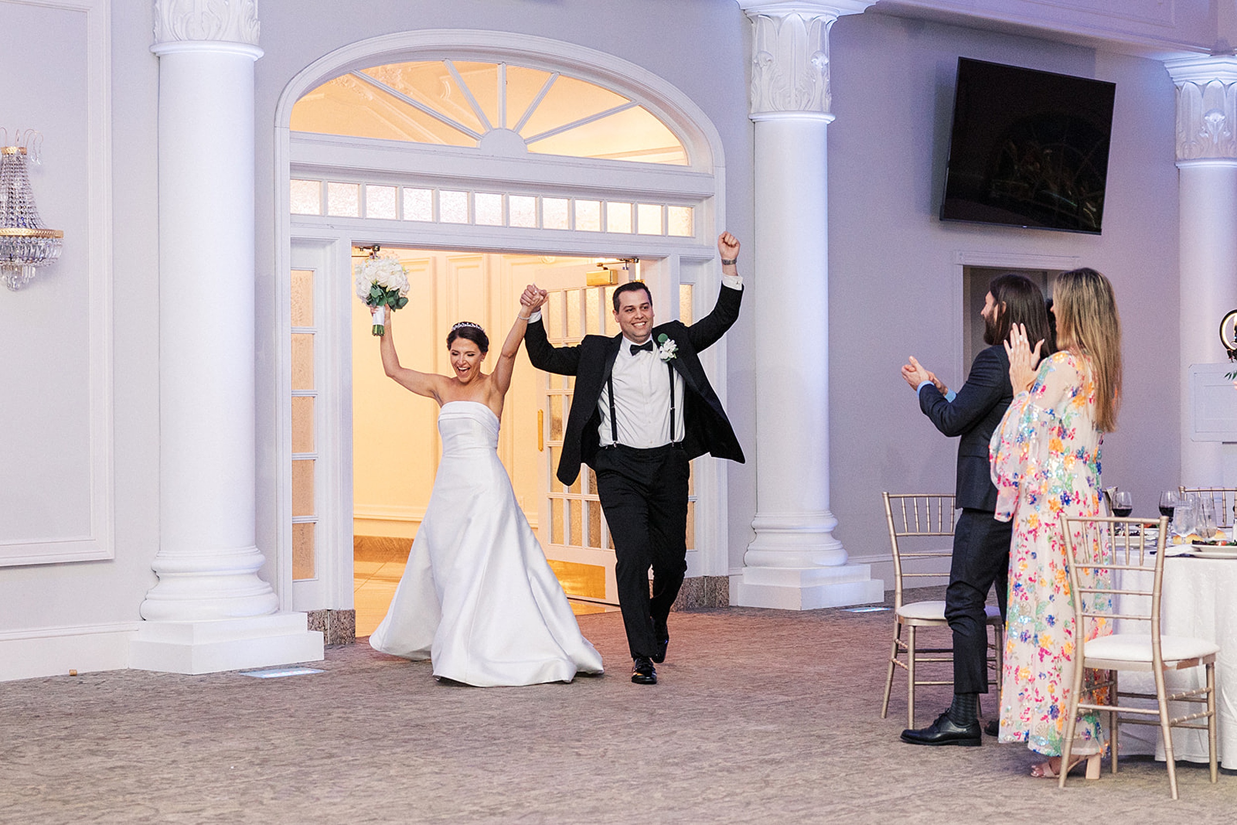 Newlyweds celebrate with guests as they enter their wedding reception