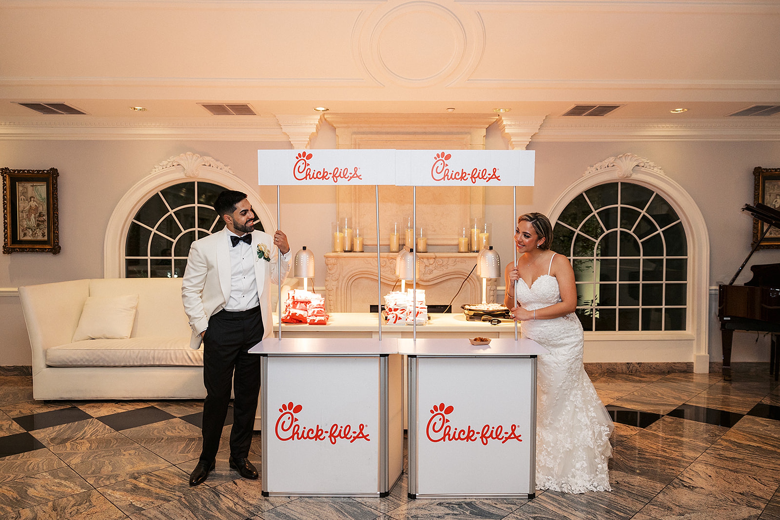 Newlyweds lean on a chick-fil-a station at their valley regency wedding while looking at each other