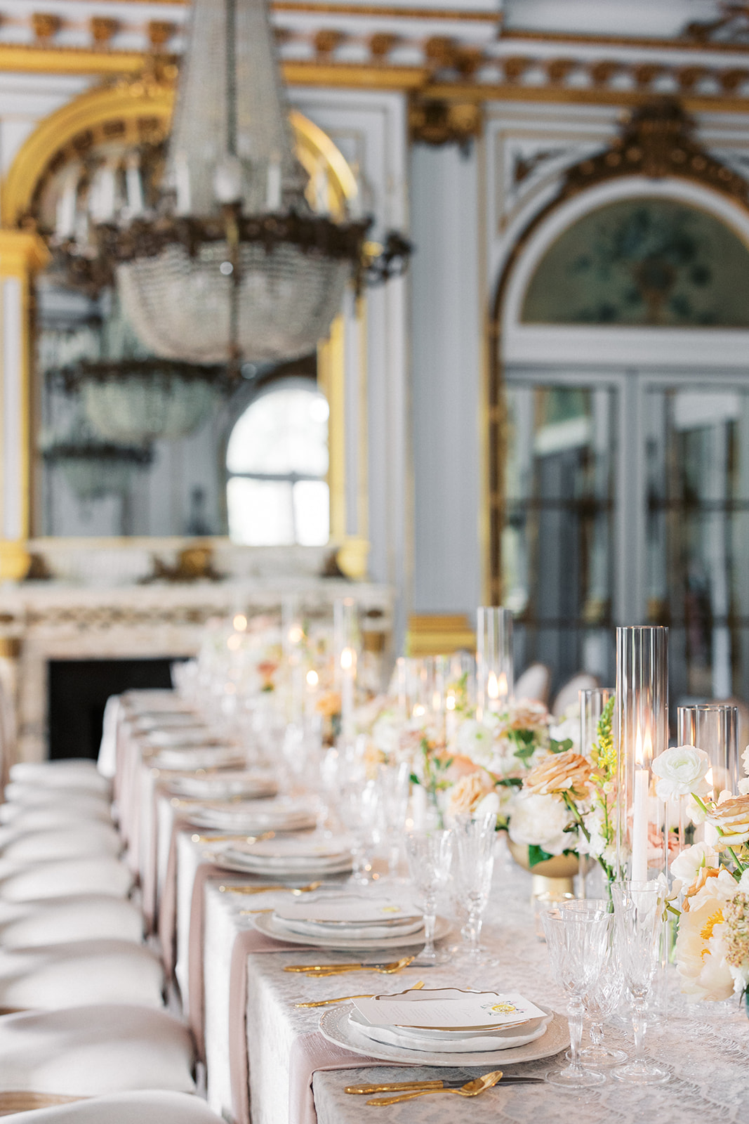 Details of a long wedding reception table with gold silverware