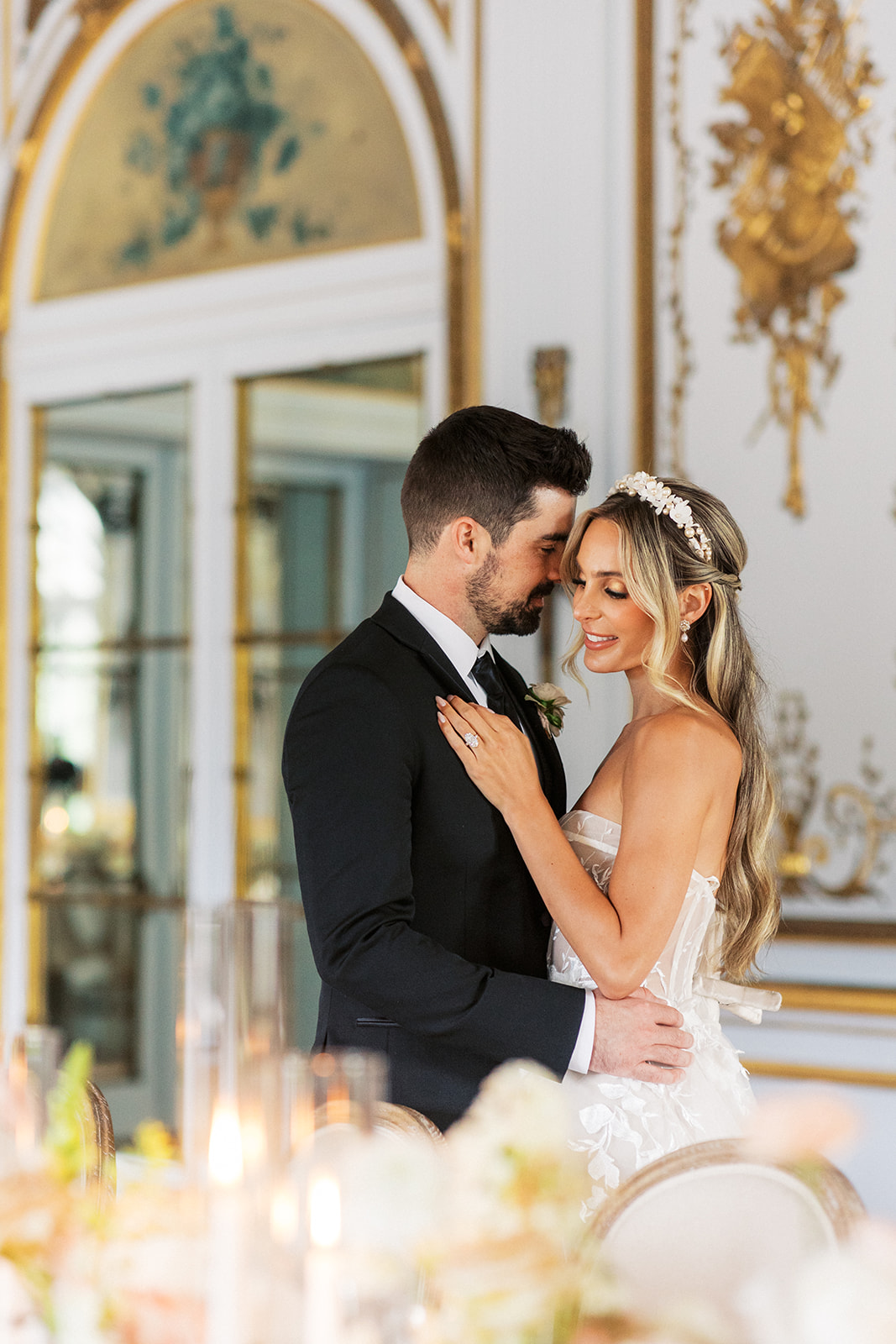 Newlyweds stand close in an ornate wedding reception room at the Elkins Estate