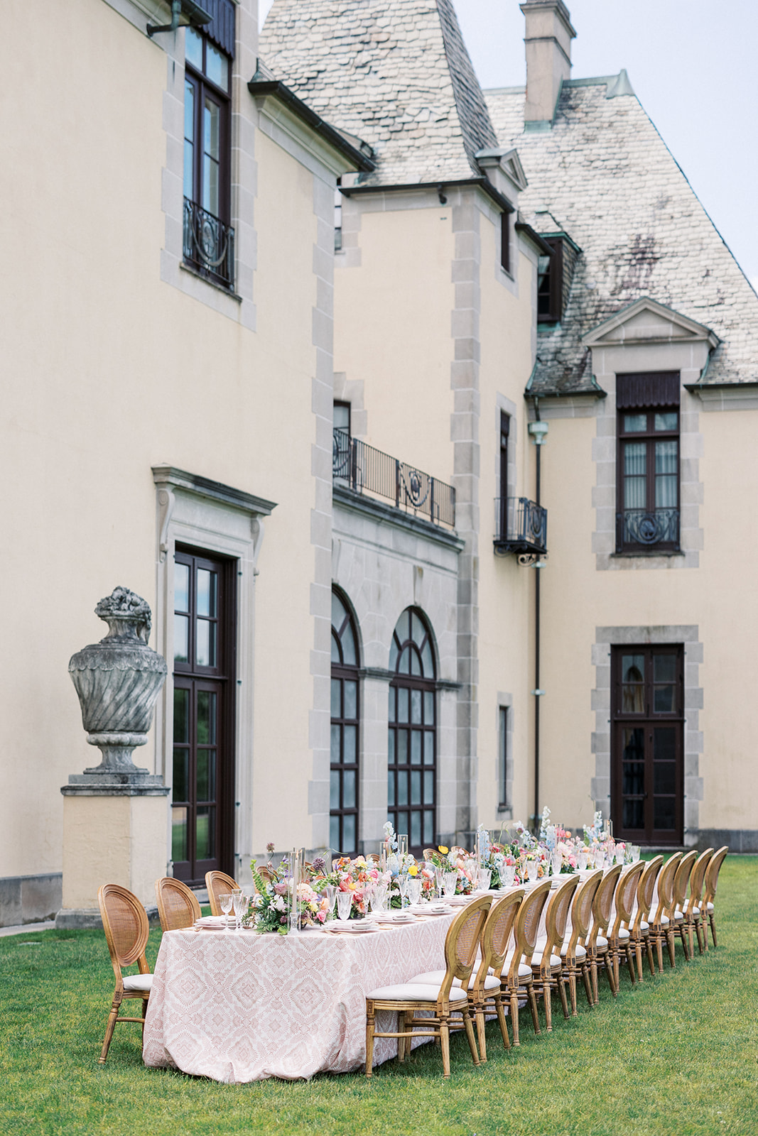 Details of a long wedding reception table set up outside in the lawn of the Oheka Castle