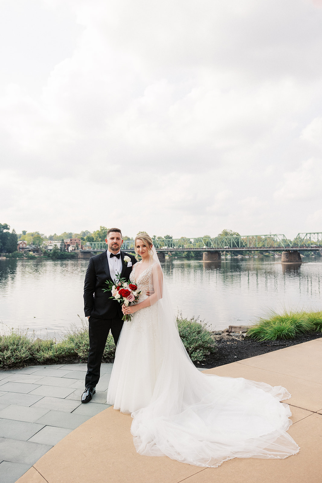 Newlyweds stand together on a riverfront patio at Lambertville Station Wedding venue