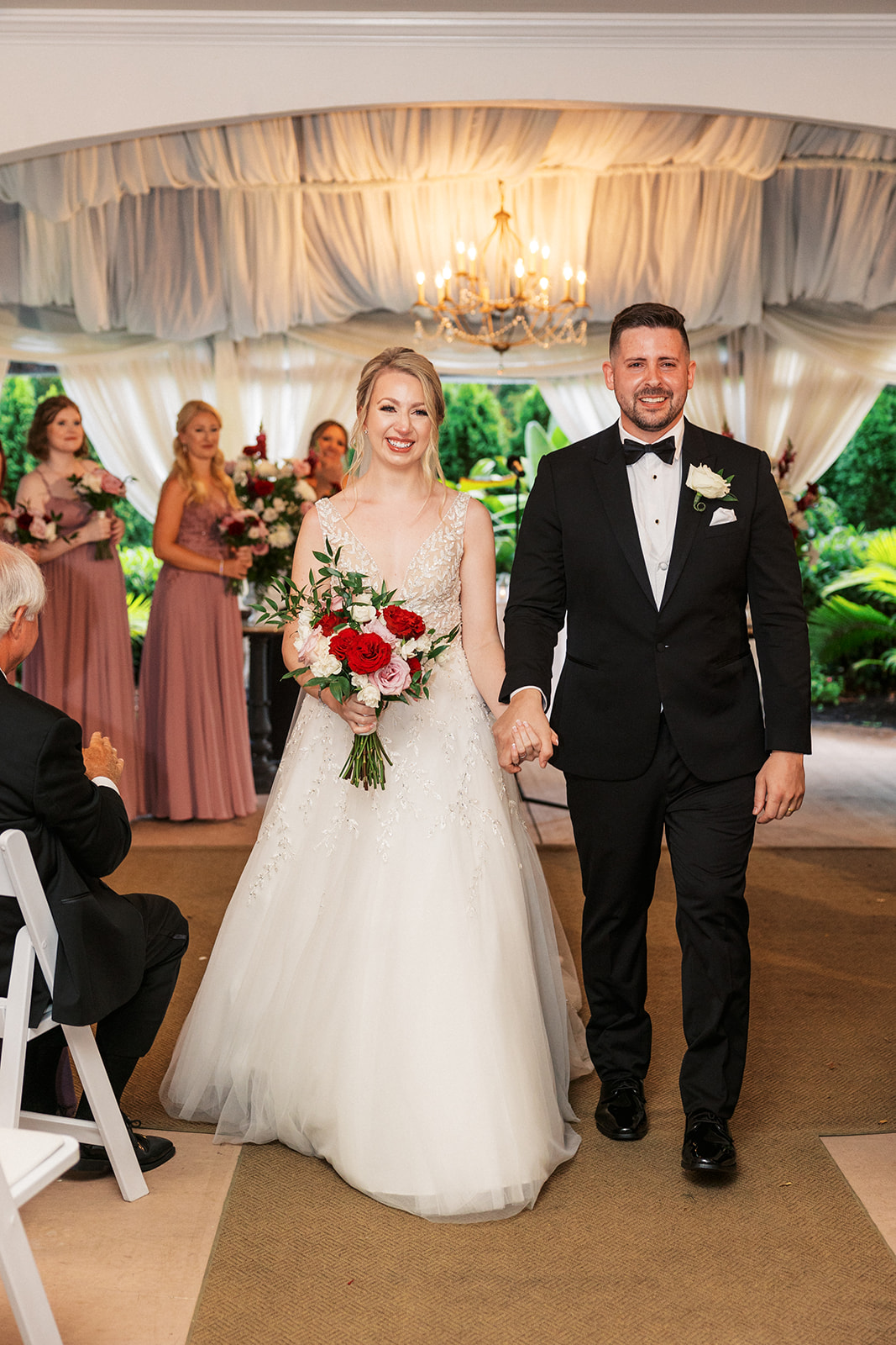 Newlyweds smile while walking back up the aisle after their wedding ceremony