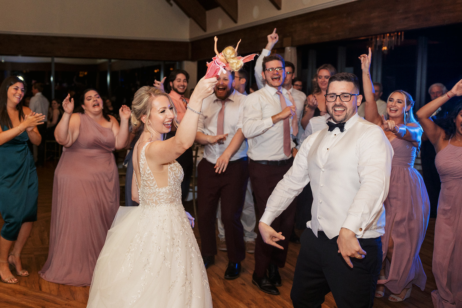 Newlyweds dance with their wedding party on the dance floor
