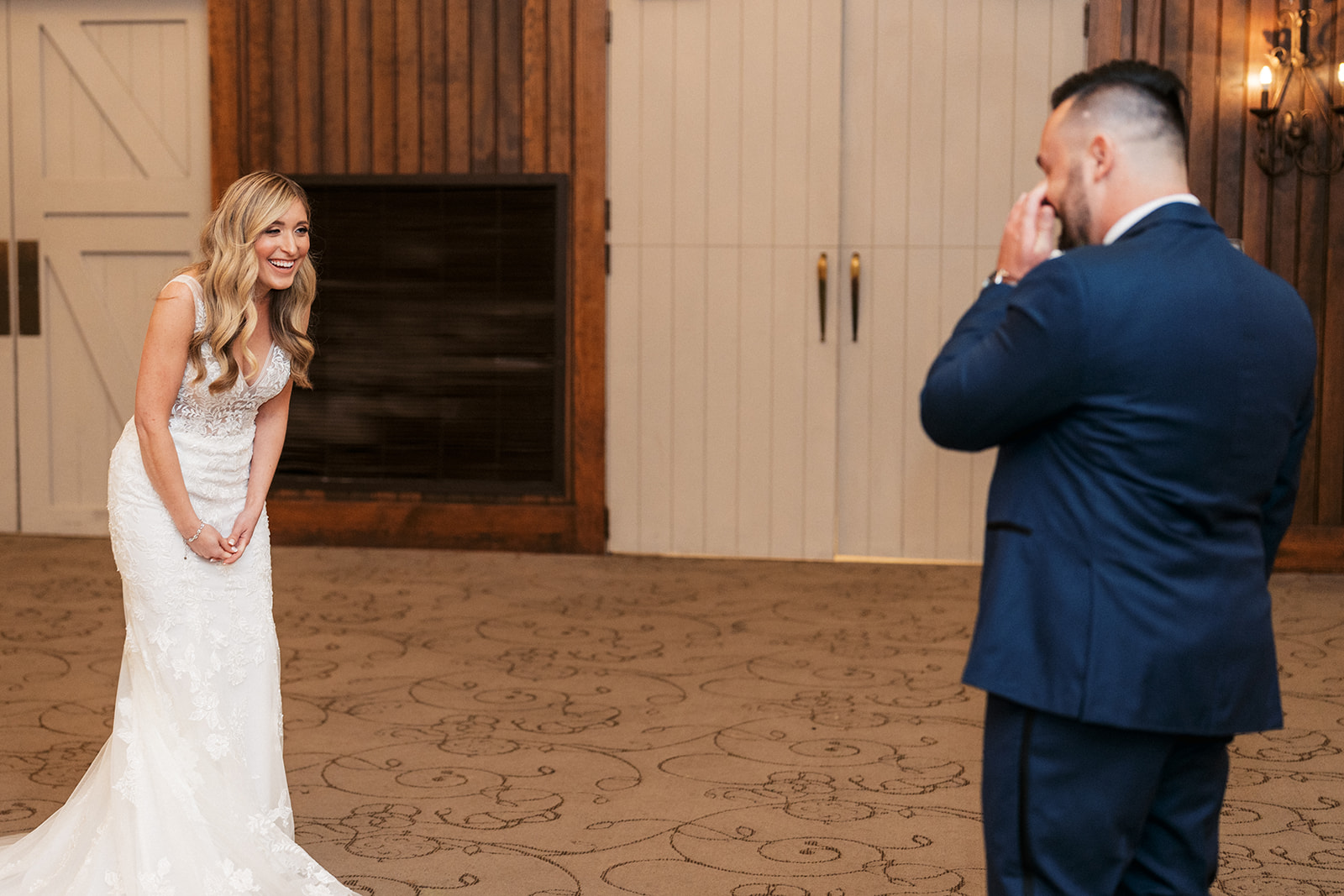 A groom wipes his eyes as he sees his bride for the first time on their wedding day