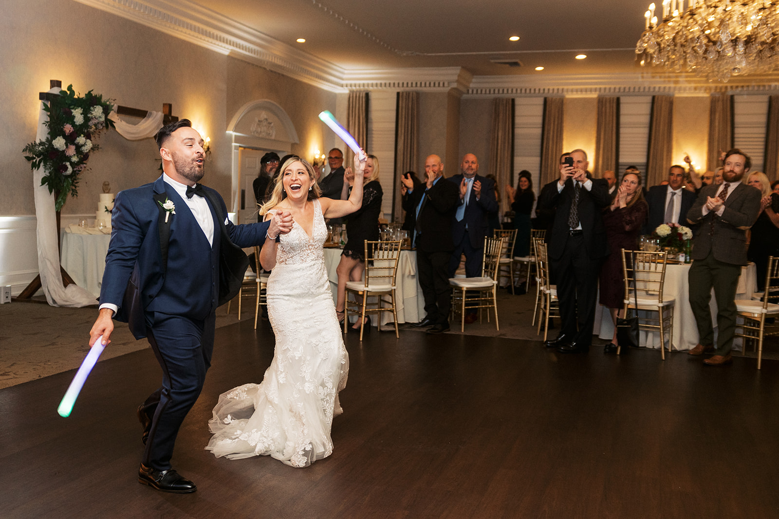 Newlyweds enter their The Belle of Blue Bell wedding reception carrying light sticks and dancing