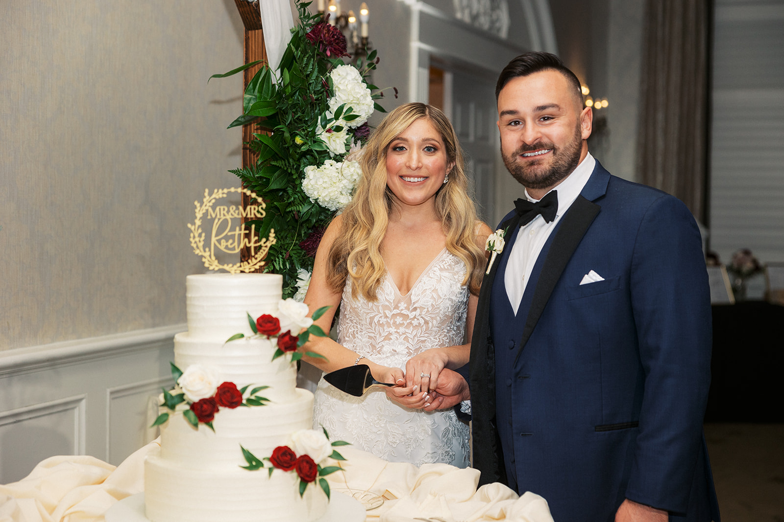 Newlyweds stand by their 4 tier cake at a The Belle of Blue Bell reception ready to cut it
