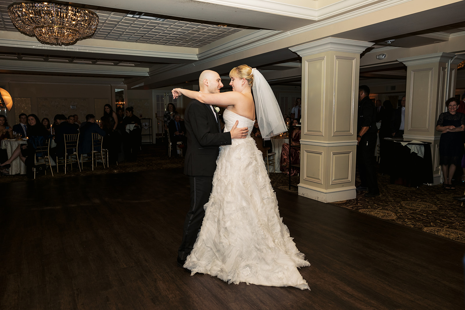 Newlyweds dance for the first time as guests look on