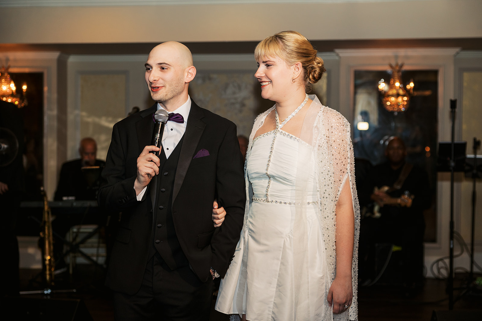 Newlyweds give a speech at their wedding reception with a wireless mic