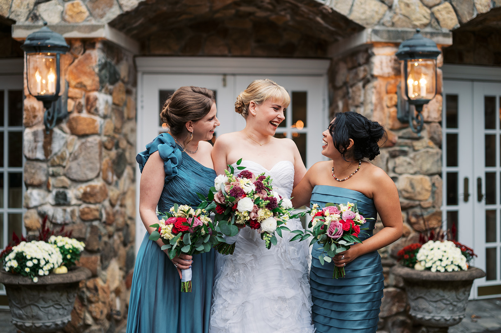 A bride laughs with her bridesmaids outside an Olde Mill Inn Wedding