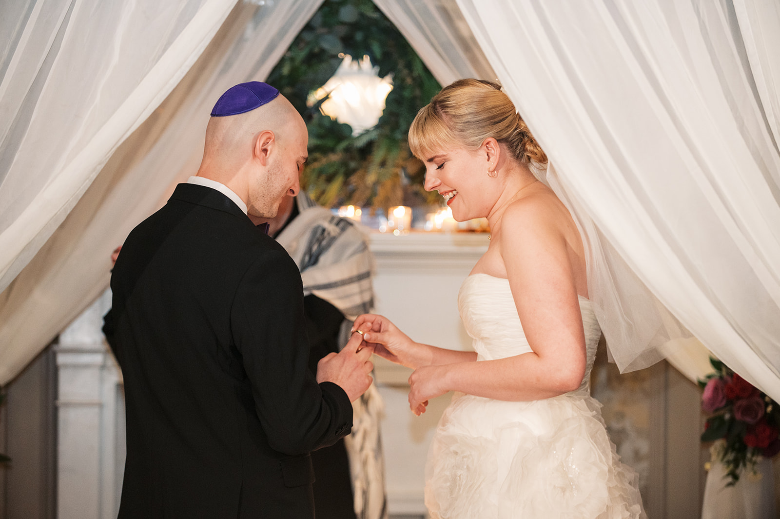 A bride puts the ring on her groom's finger at the altar