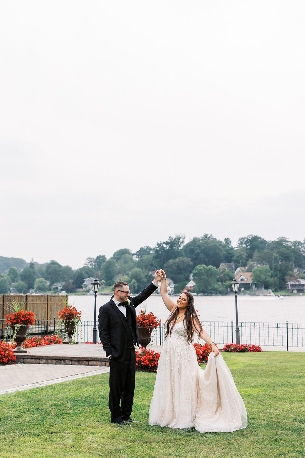 A groom twirls his bride on a waterfront garden at the Villa Barone Hilltop Manor
