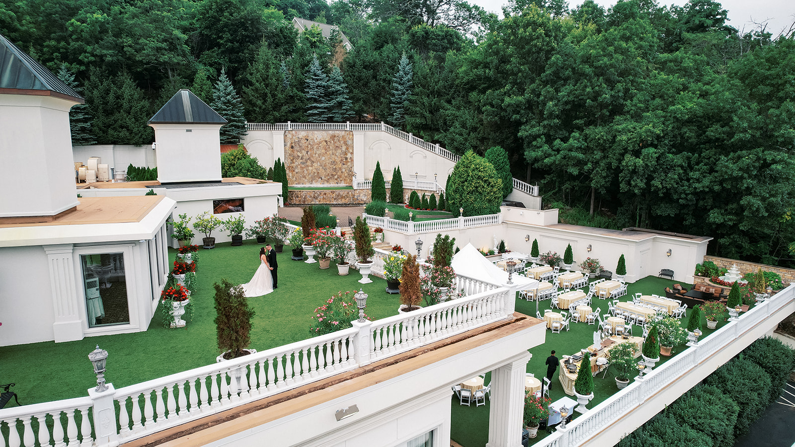 Newlyweds stand alone on a grass terrace at the Villa Barone Hilltop Manor