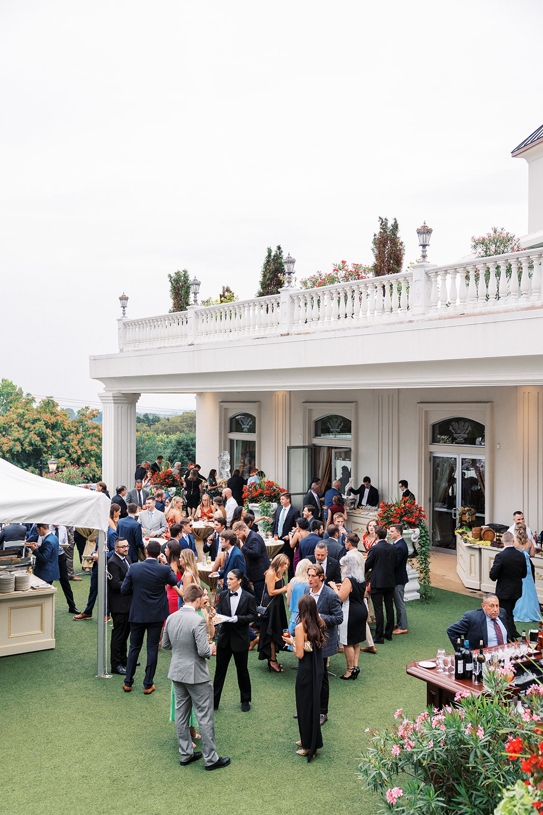 A wedding cocktail hour taking place with many guests at a Villa Barone Hilltop Manor wedding