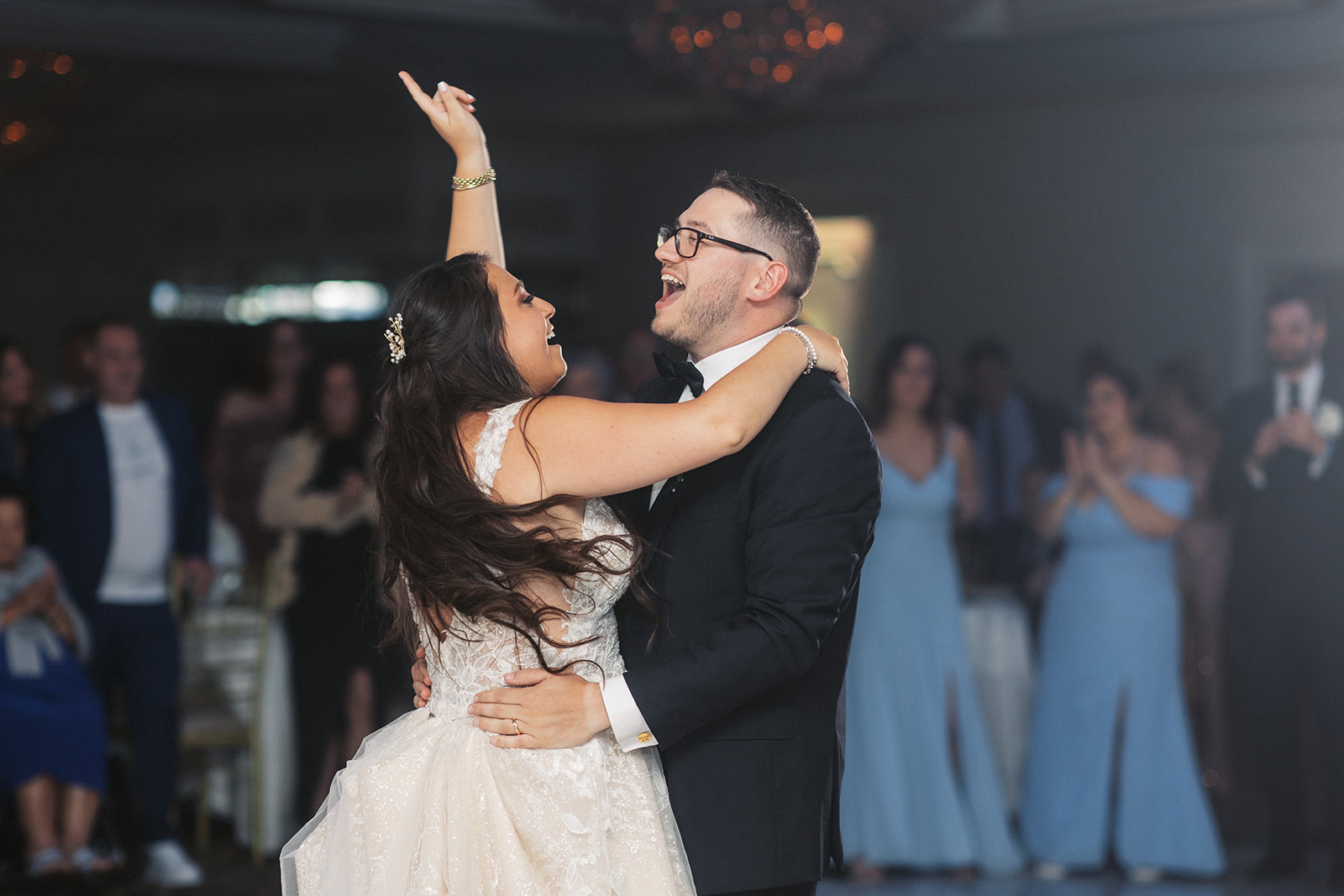 Newlyweds dance alone on the dance floor surrounded by guests and singing