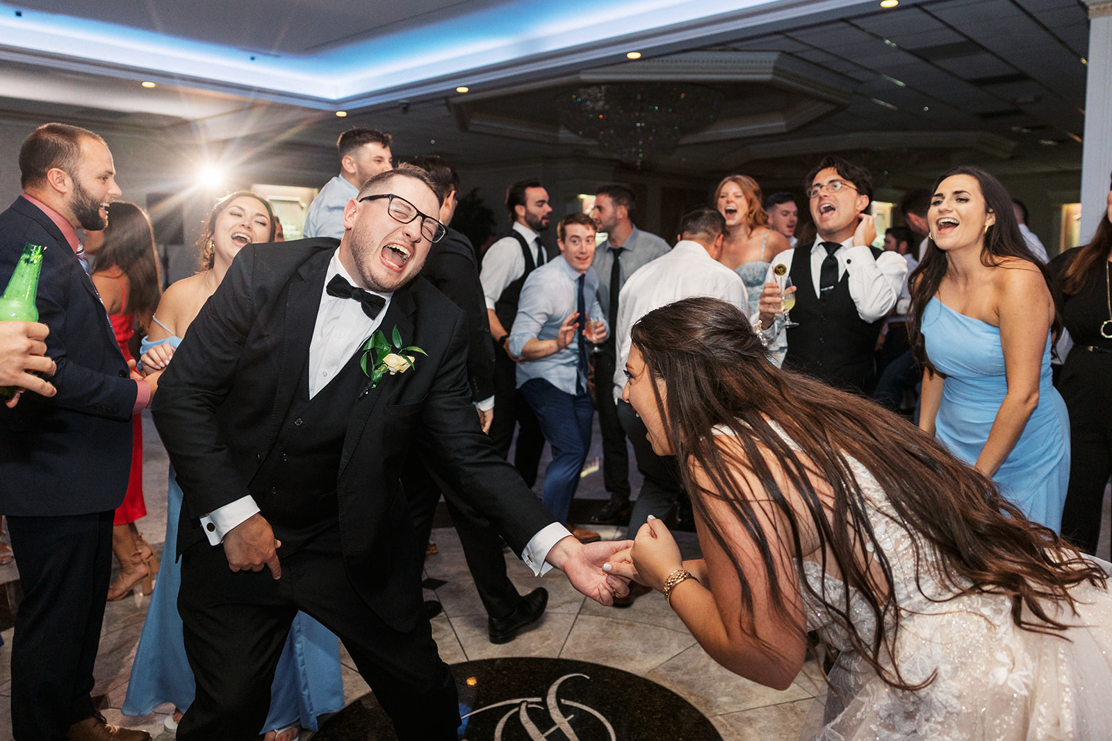 Newlyweds dance and sing on the dance floor with their guests at a Villa Barone Hilltop Manor wedding reception