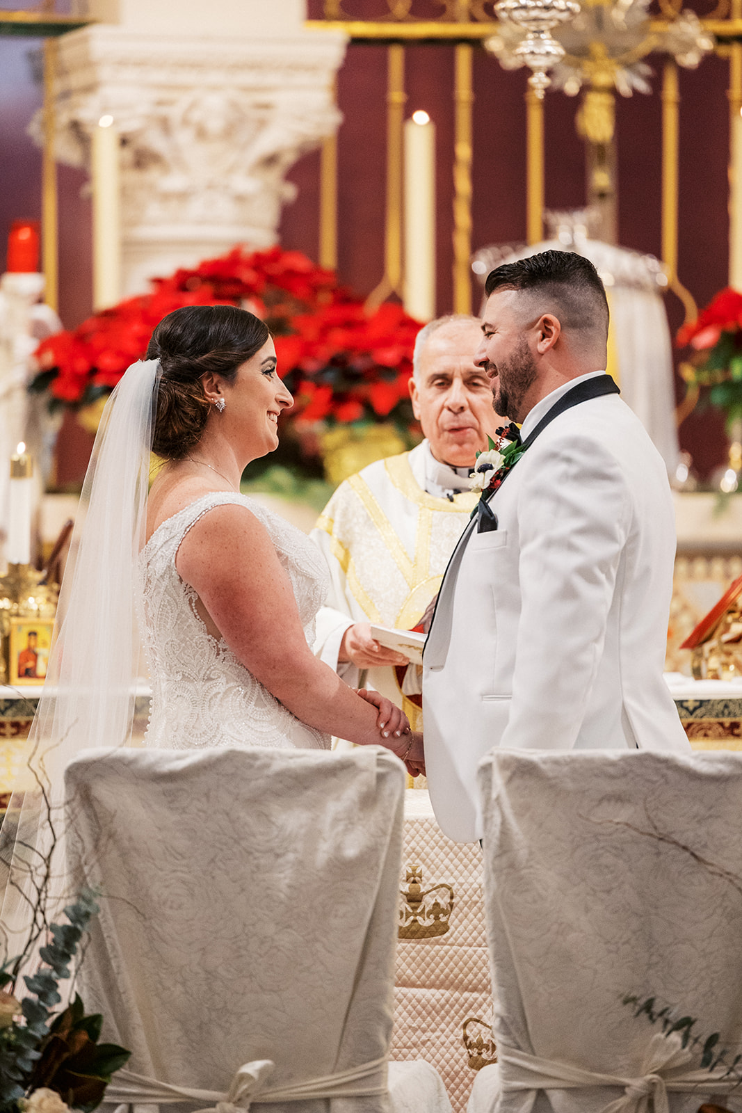 Newlyweds stand together holding hands at the altar during their ceremony