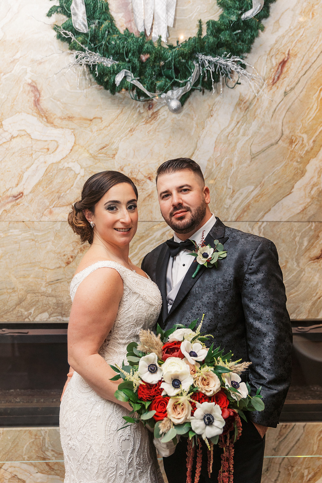 Newlyweds stand together in a marble hallway at their Above Weddings