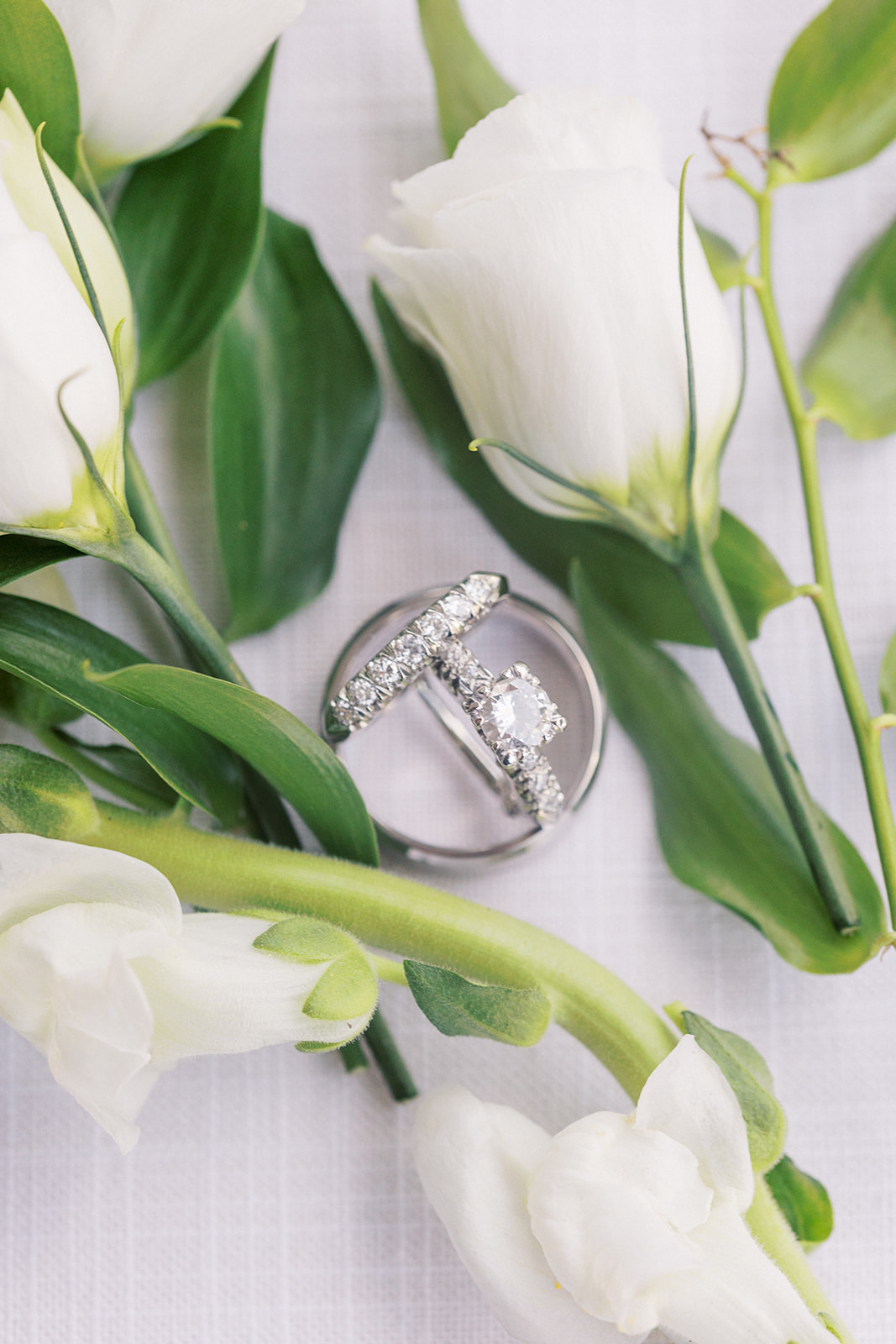 Wedding rings sit among white flowers