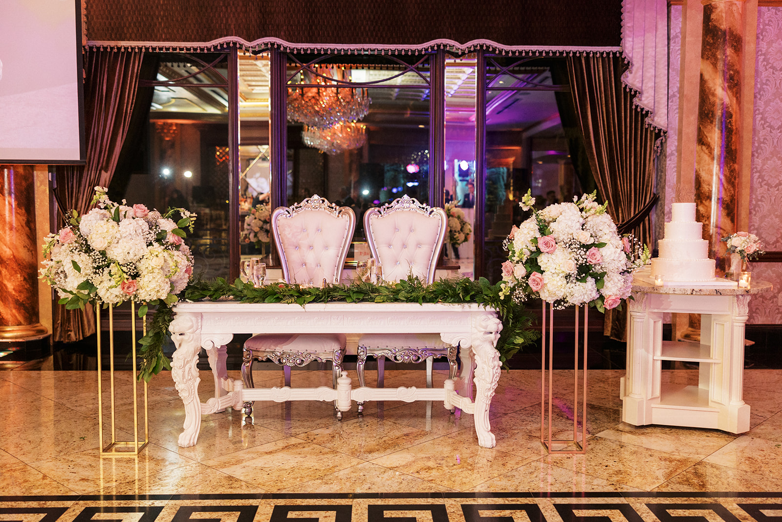 A newlyweds head table sits decorated on granite floors at a Seasons Catering Wedding