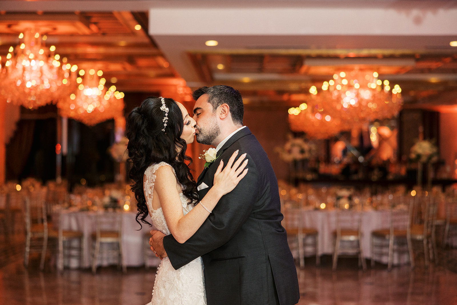 Newlyweds share a kiss while in their empty Seasons Catering Wedding reception hall